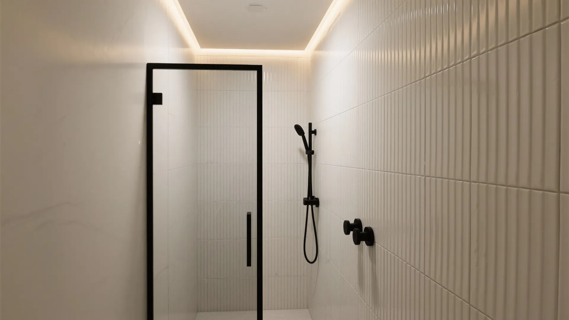 Vertical ribbed tiles lit by a ceiling LED wall washer creating tall shadow lines.