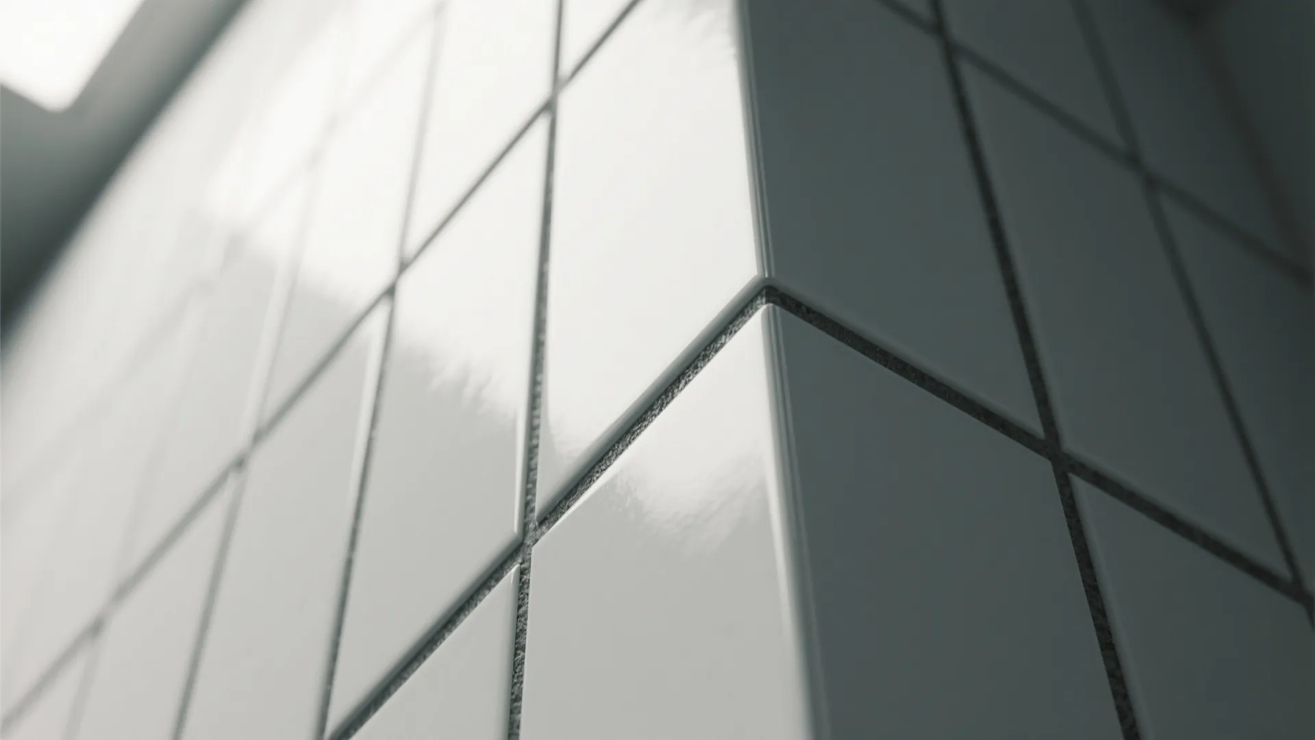 Close up view of white square wall tiles with dark grout lines in a modern bathroom