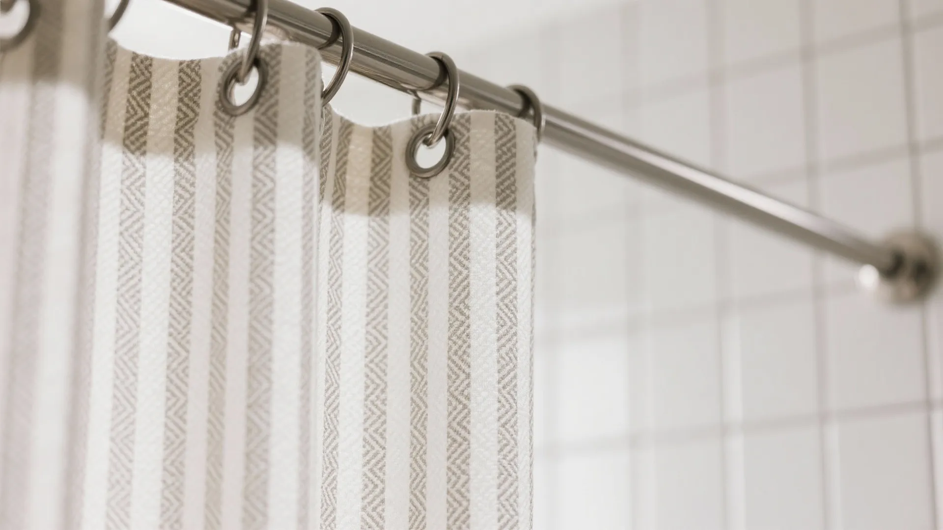 Macro view of curtain fabric with soft vertical stripes and micro-print, metal rings, and clean weave.