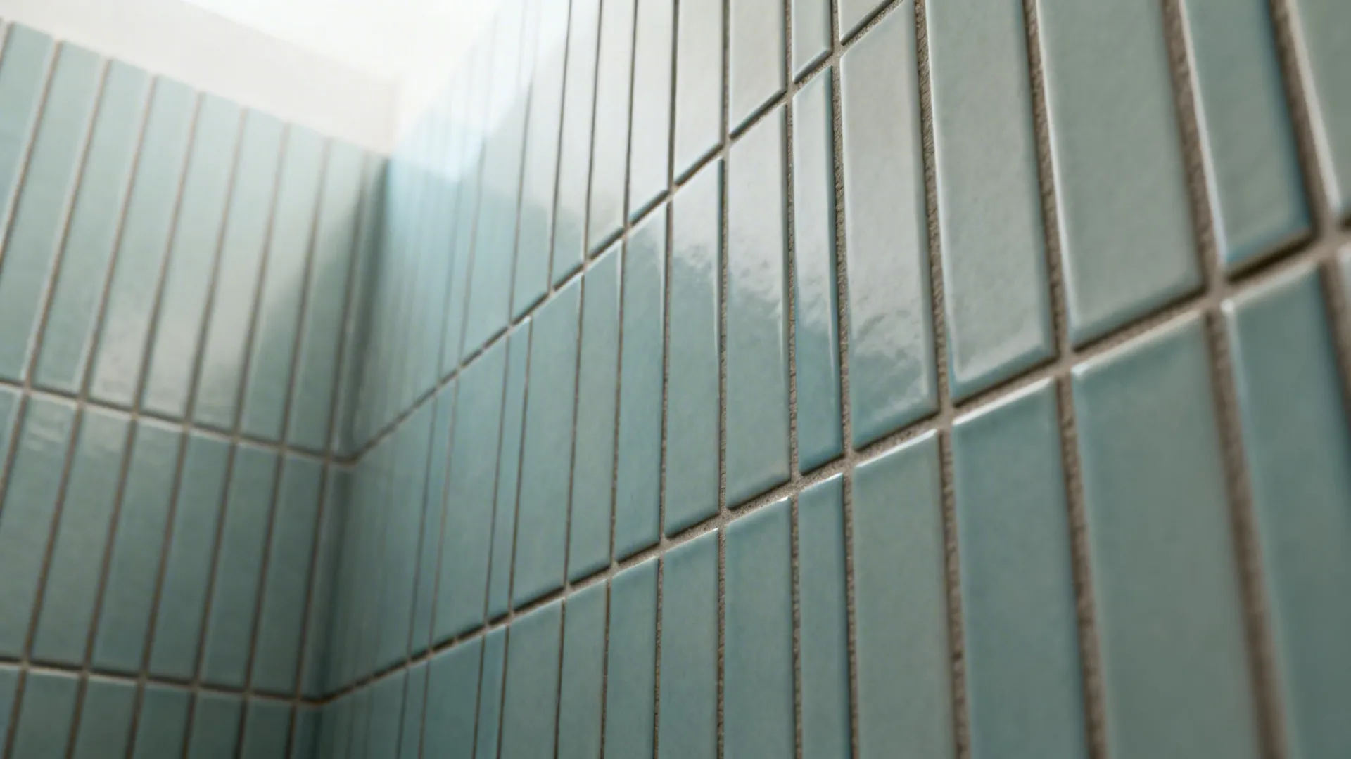 Close-up of vertically stacked subway tiles with matching grout in a small shower.