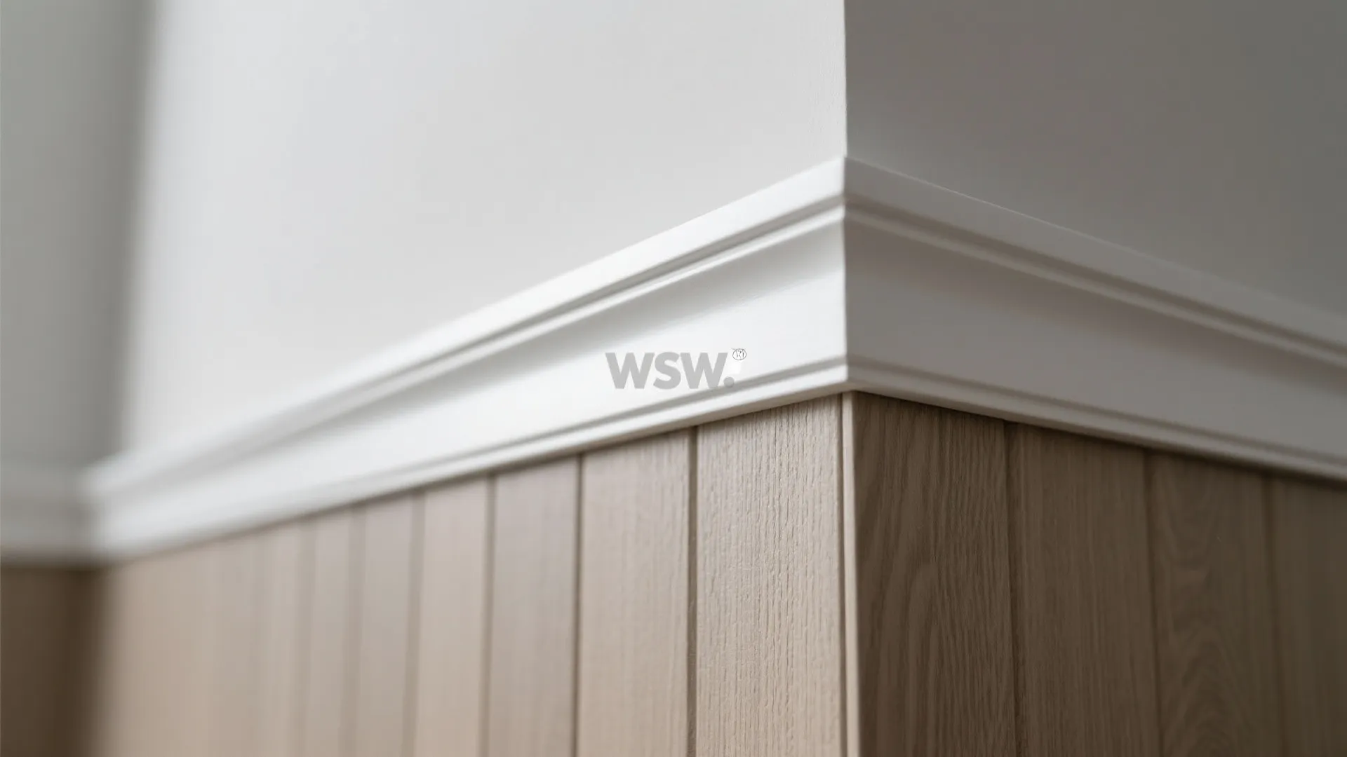 Close up of white wall trim meeting light wooden wall panel in a modern home