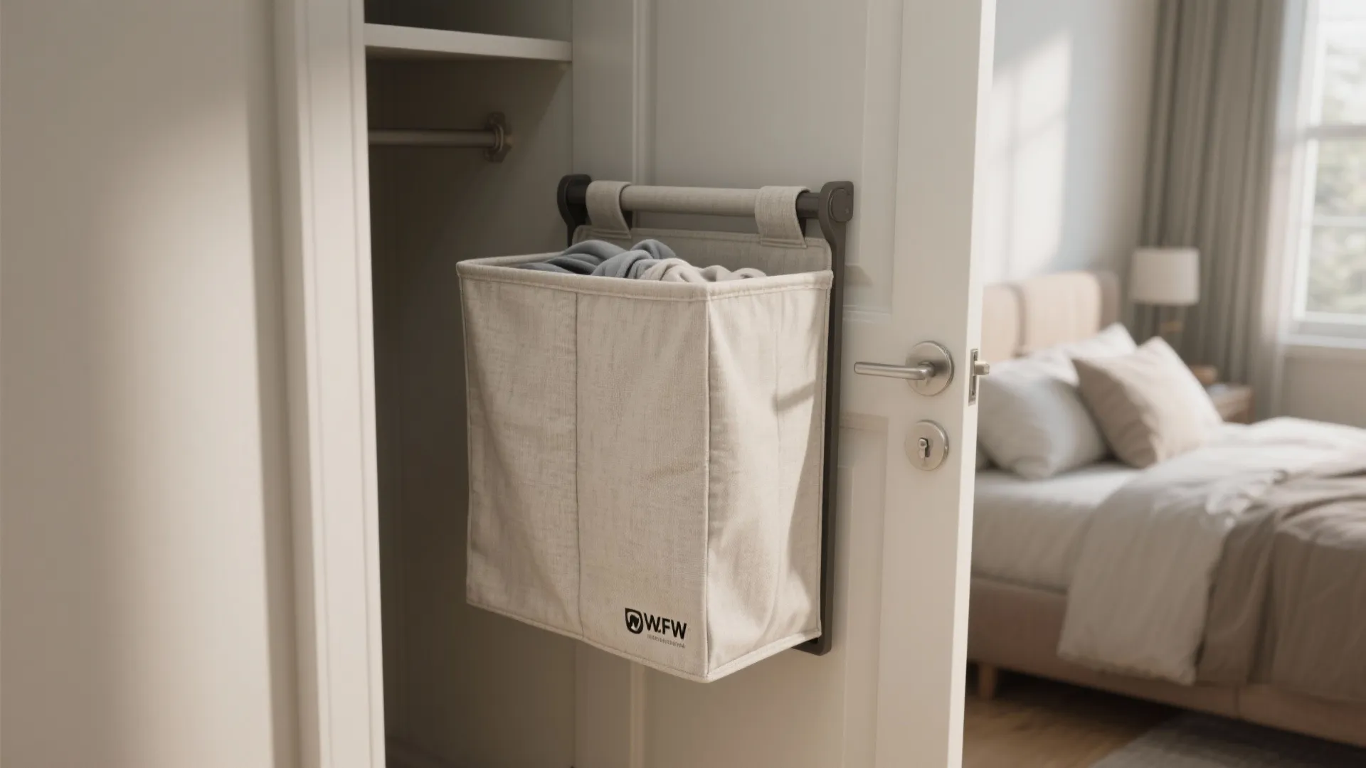 Beige fabric laundry bag hanging on a white bedroom door for convenient and compact storage