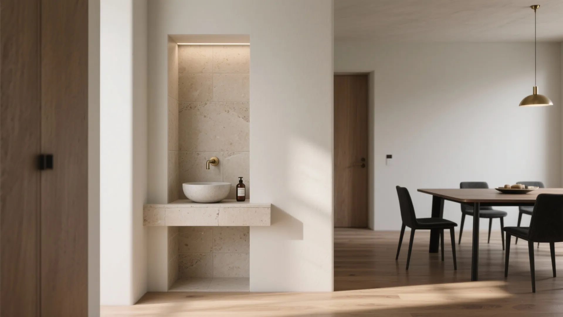 Minimalist wall niche with stone wash basin gold tap and dining room with black chairs