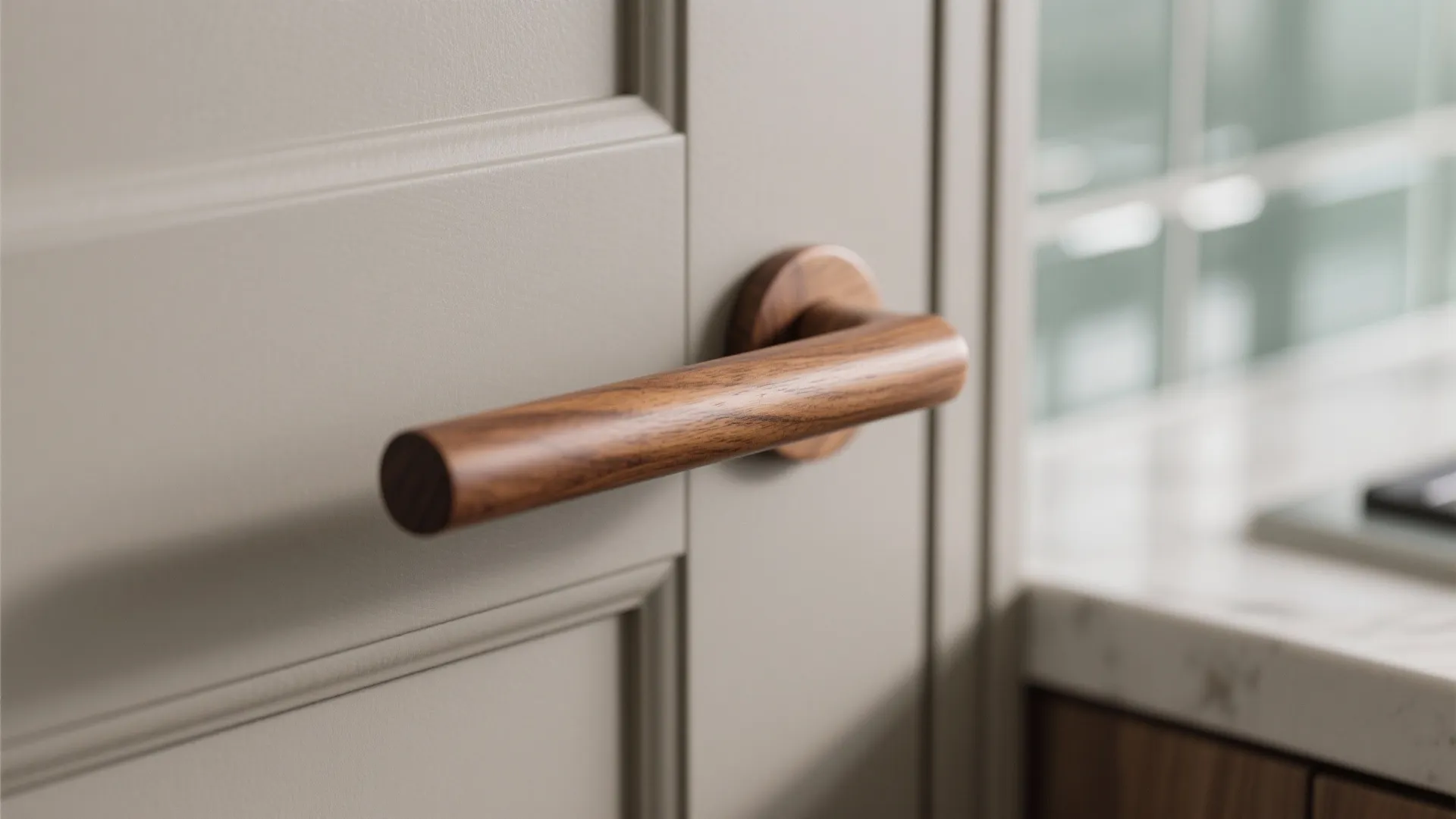 Close up view of a round wooden door handle on a grey cabinet door panel