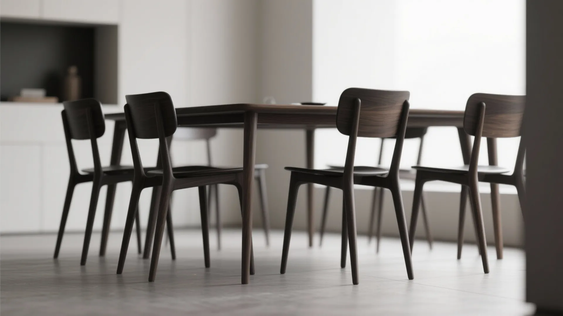 Modern wooden dining table set with four dark brown chairs in a bright minimalist room