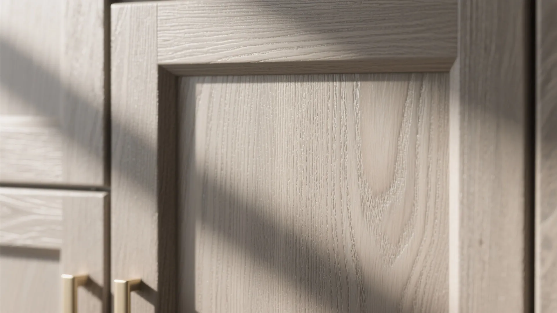 Close up view of warm grey oak wood grain texture on a modern kitchen cabinet