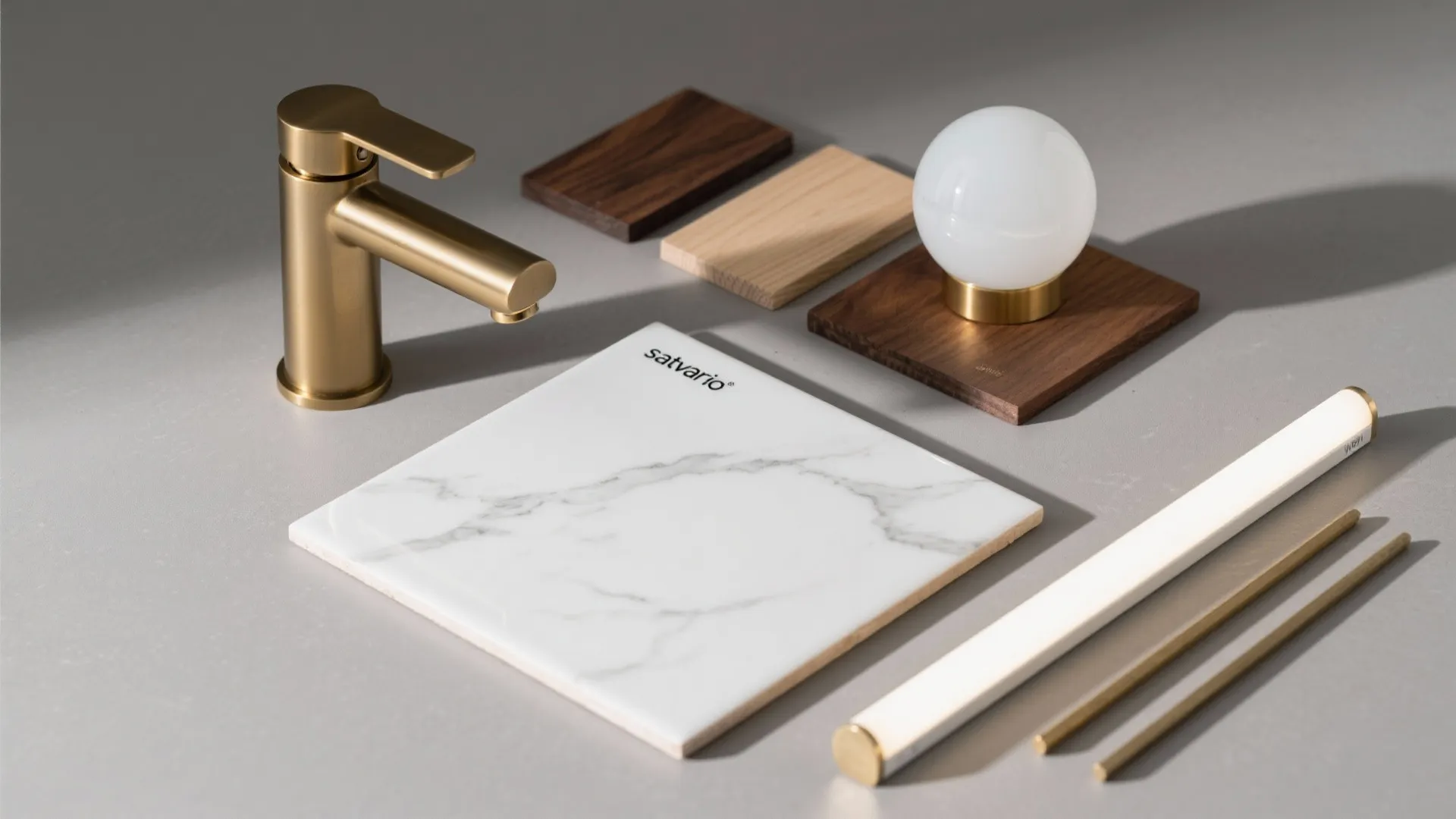 Interior design materials including white marble tile gold faucet wood samples and a small light