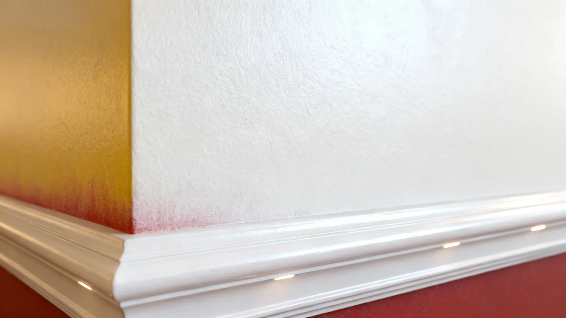 Macro of warm white wall against crisp white trim showing subtle undertones and sheen.