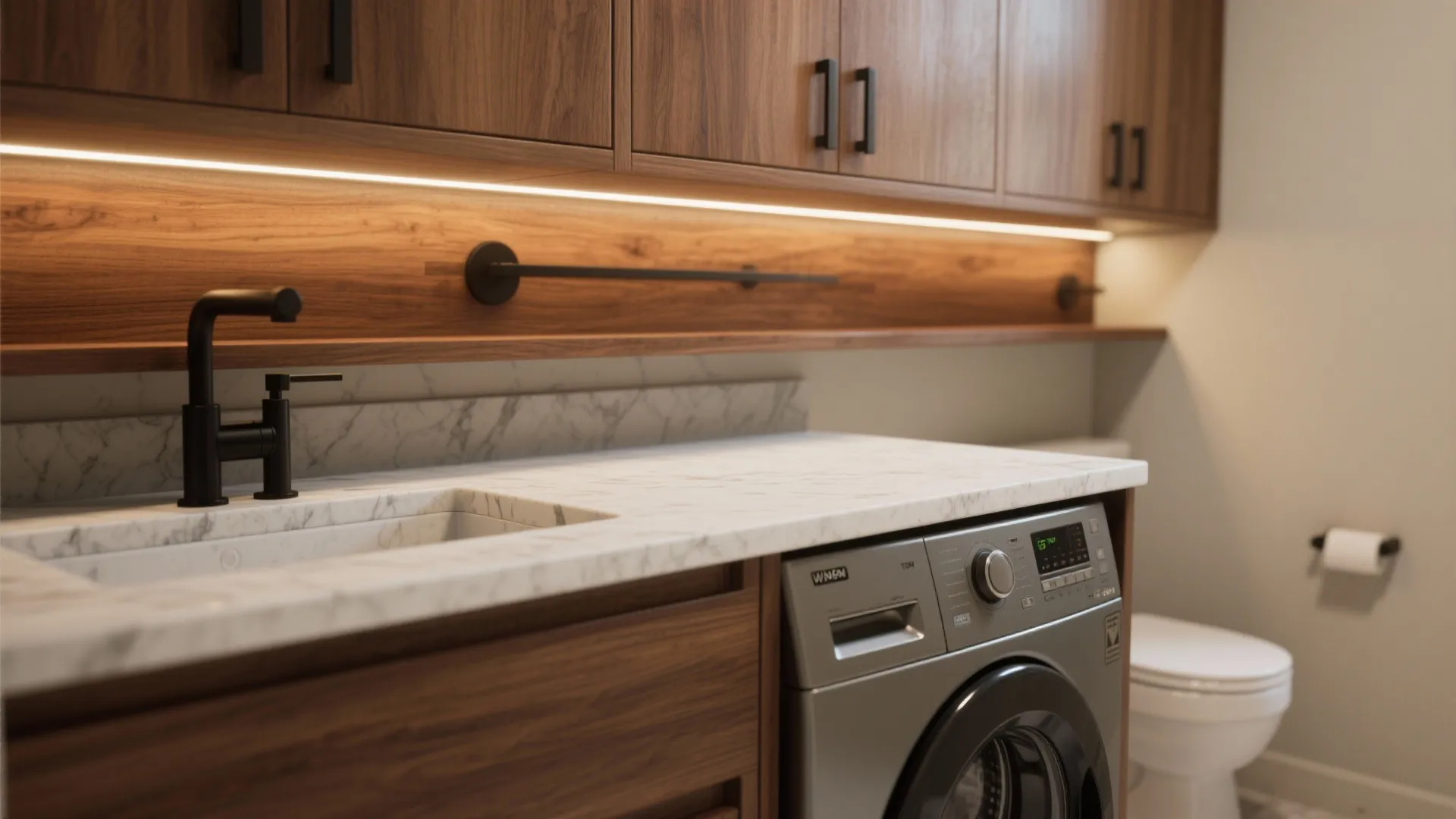 Close up of marble countertop with integrated sink next to grey washing machine and wood