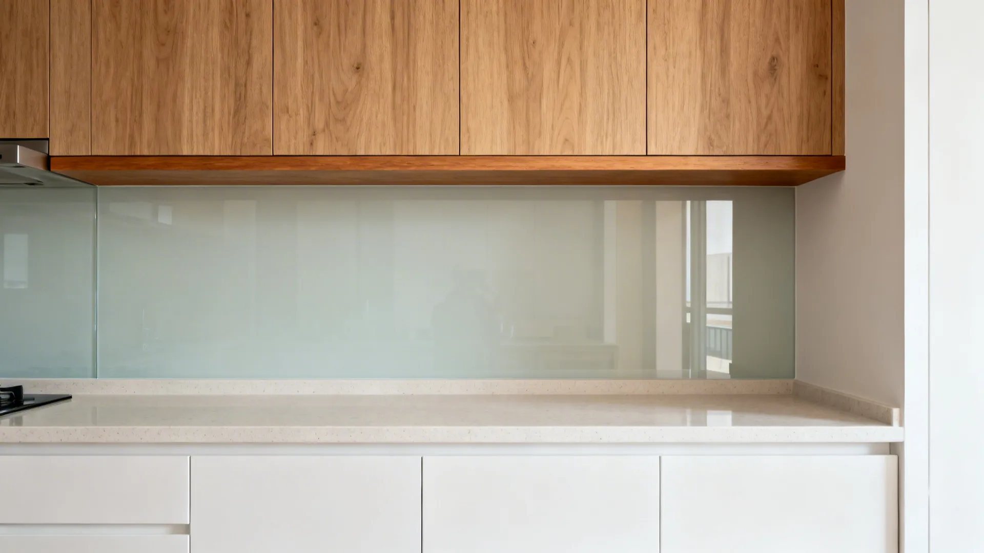 Minimalist kitchen with oak-look uppers and a slim wood shelf over white lowers.