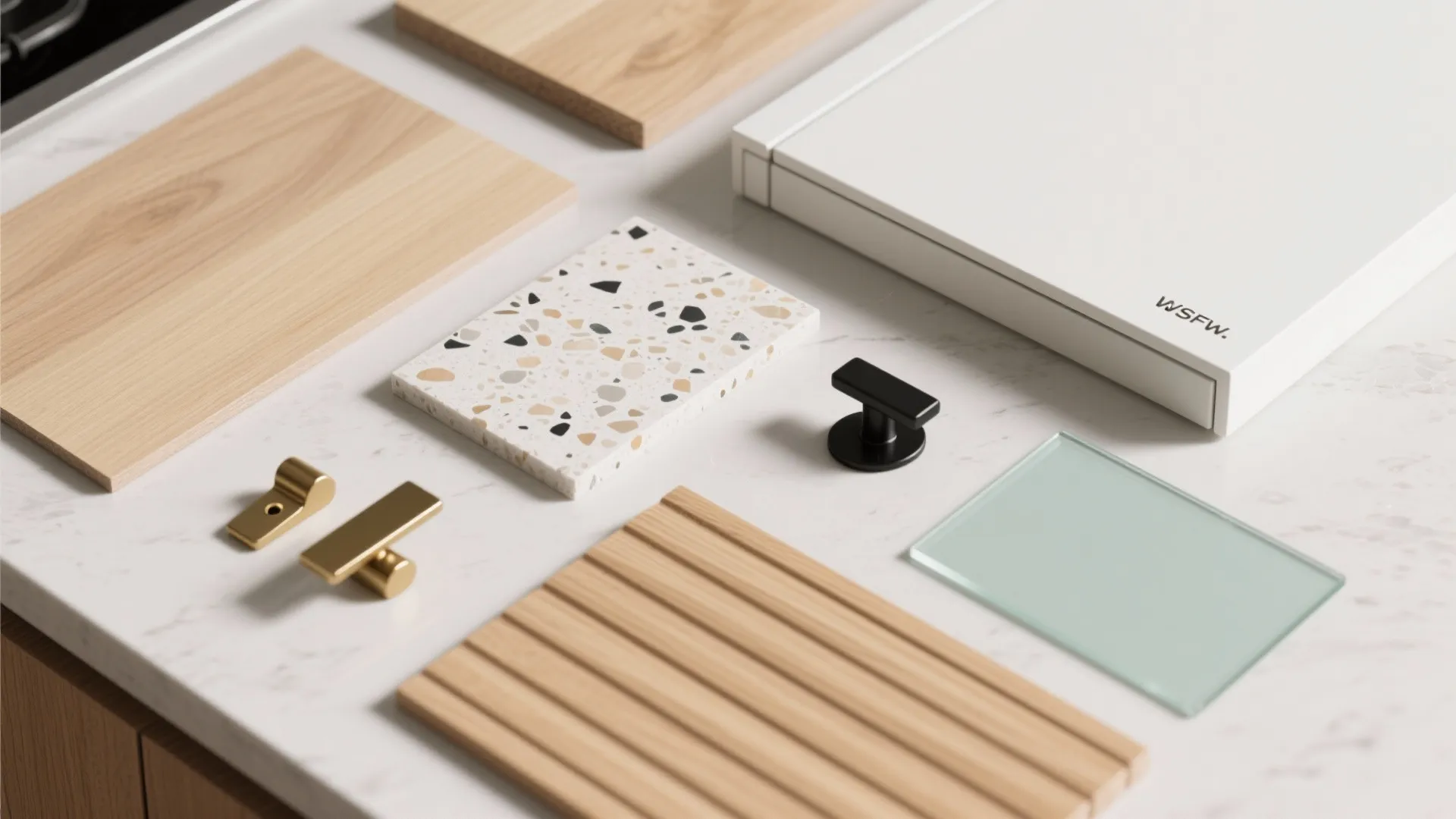 Interior design material samples with wood pieces stone tile metal handles and glass on marble surface