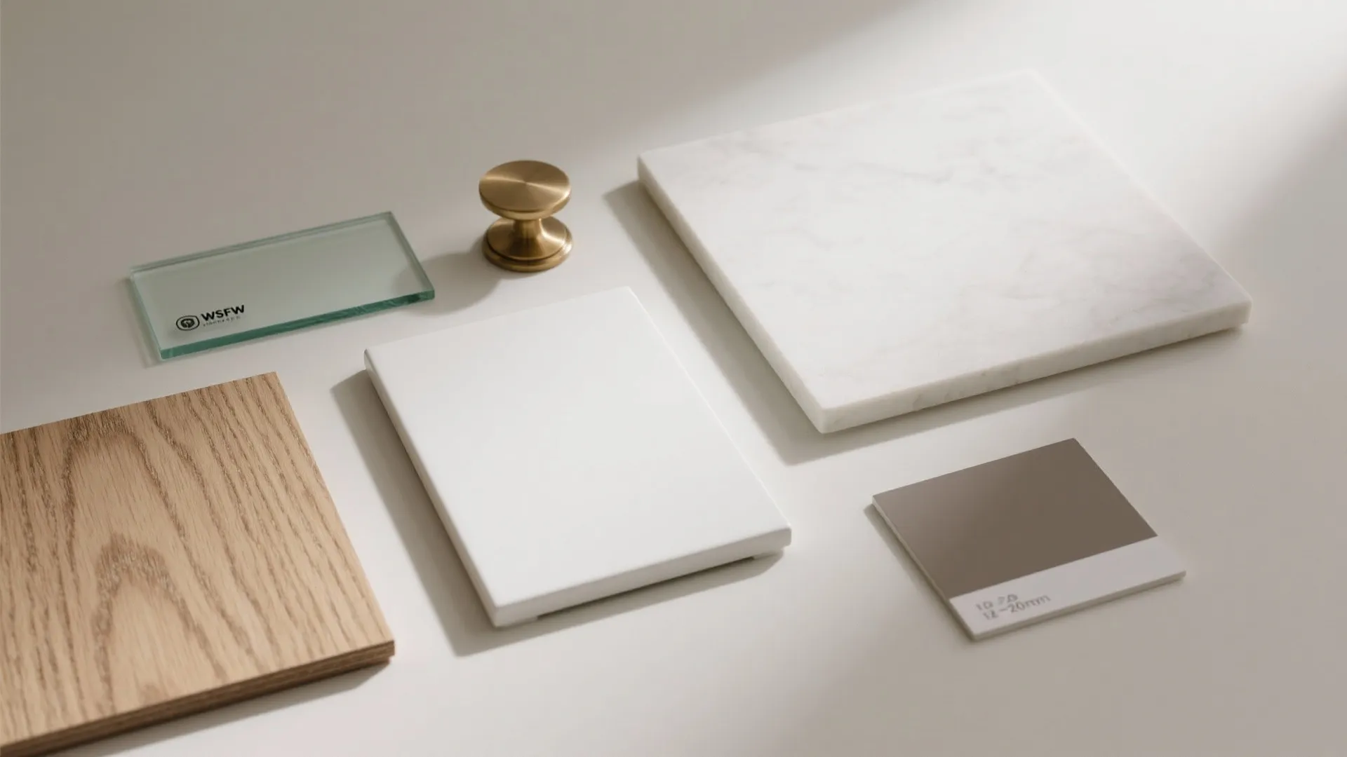 Interior design material samples including wood panel, marble tile, white stone, glass, and gold handle