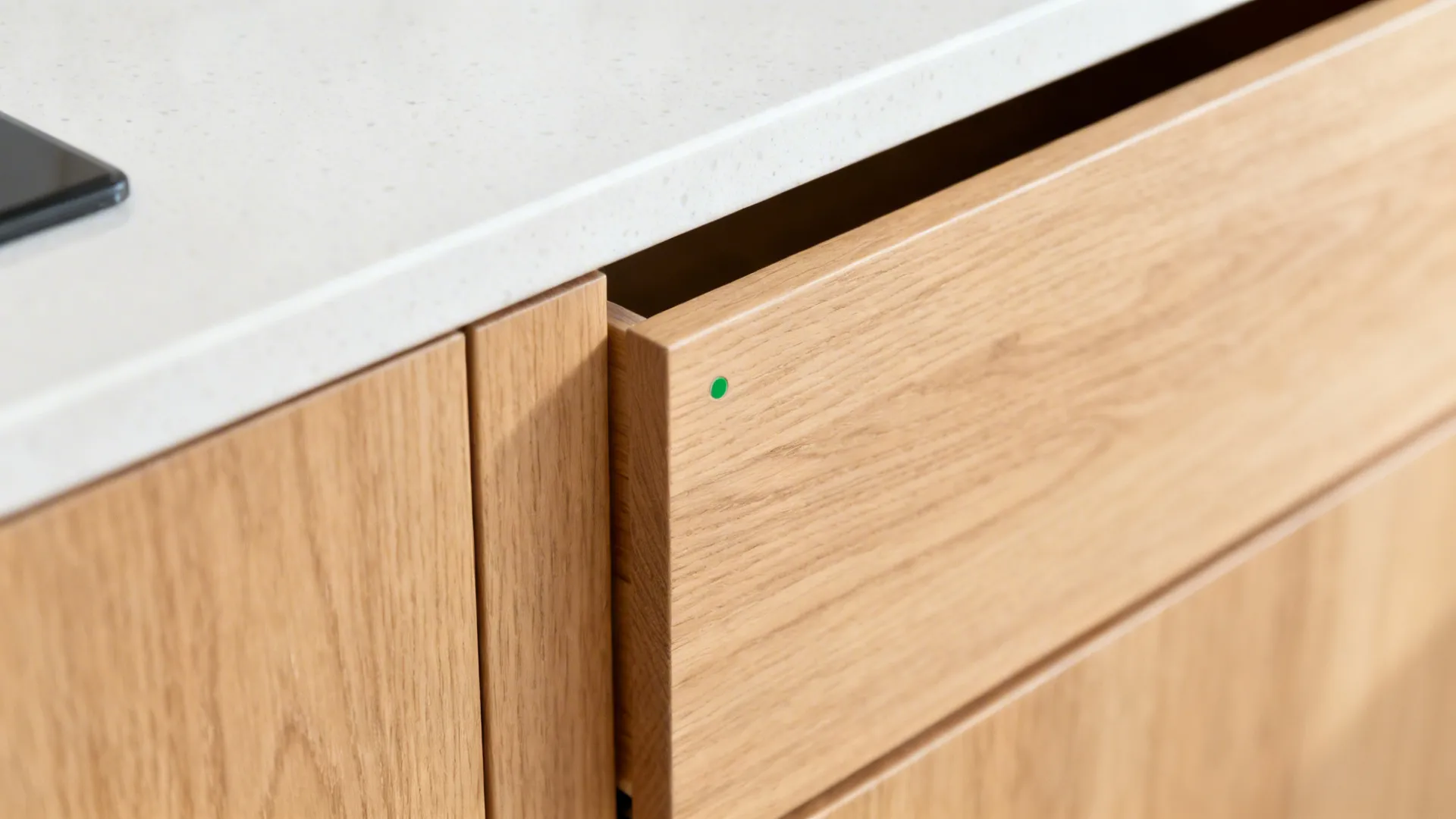 Close-up of matte oak drawer fronts beside white quartz, highlighting friendly wood texture.