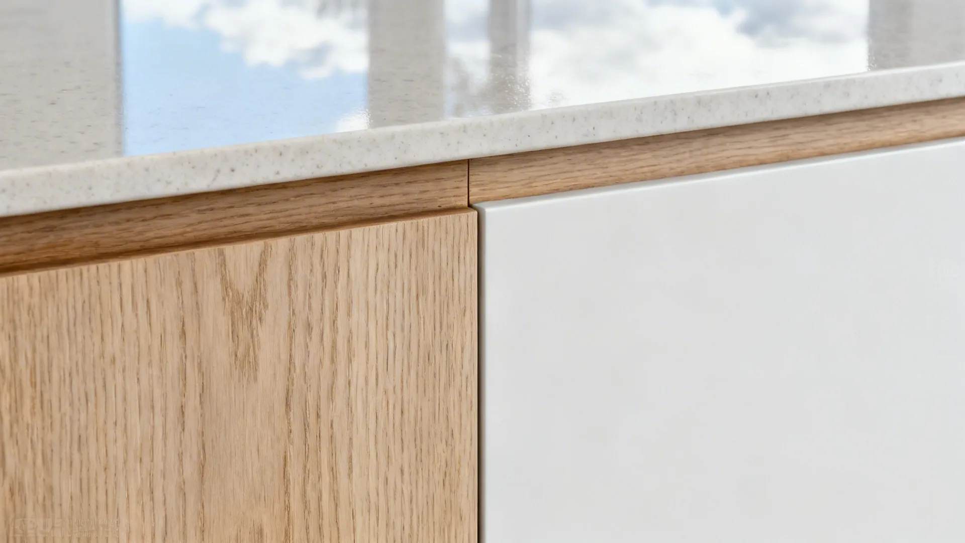 Macro of rift-cut white oak next to matte white panel and light quartz countertop.