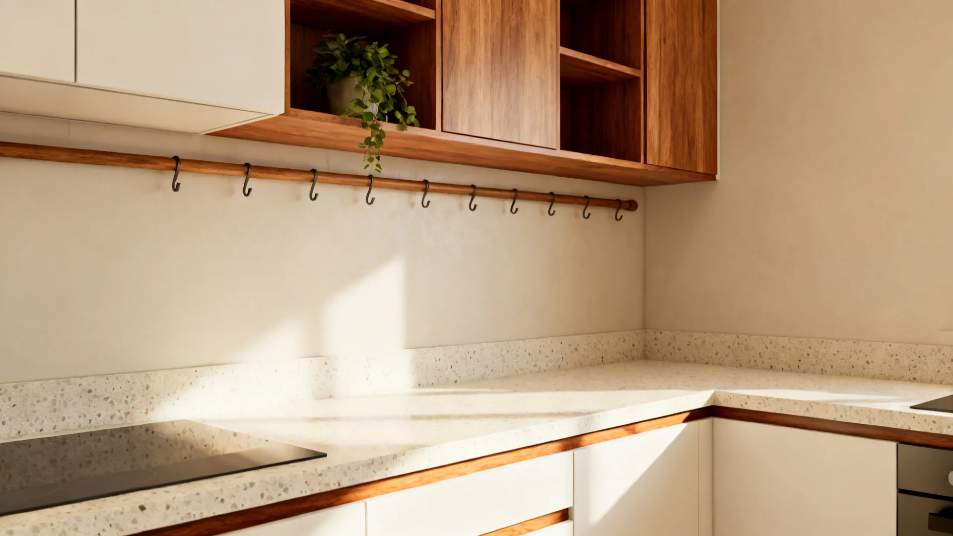 Small kitchen scene with terrazzo-look counters, warm-white cabinets, kiaat shelves, and a timber rail.