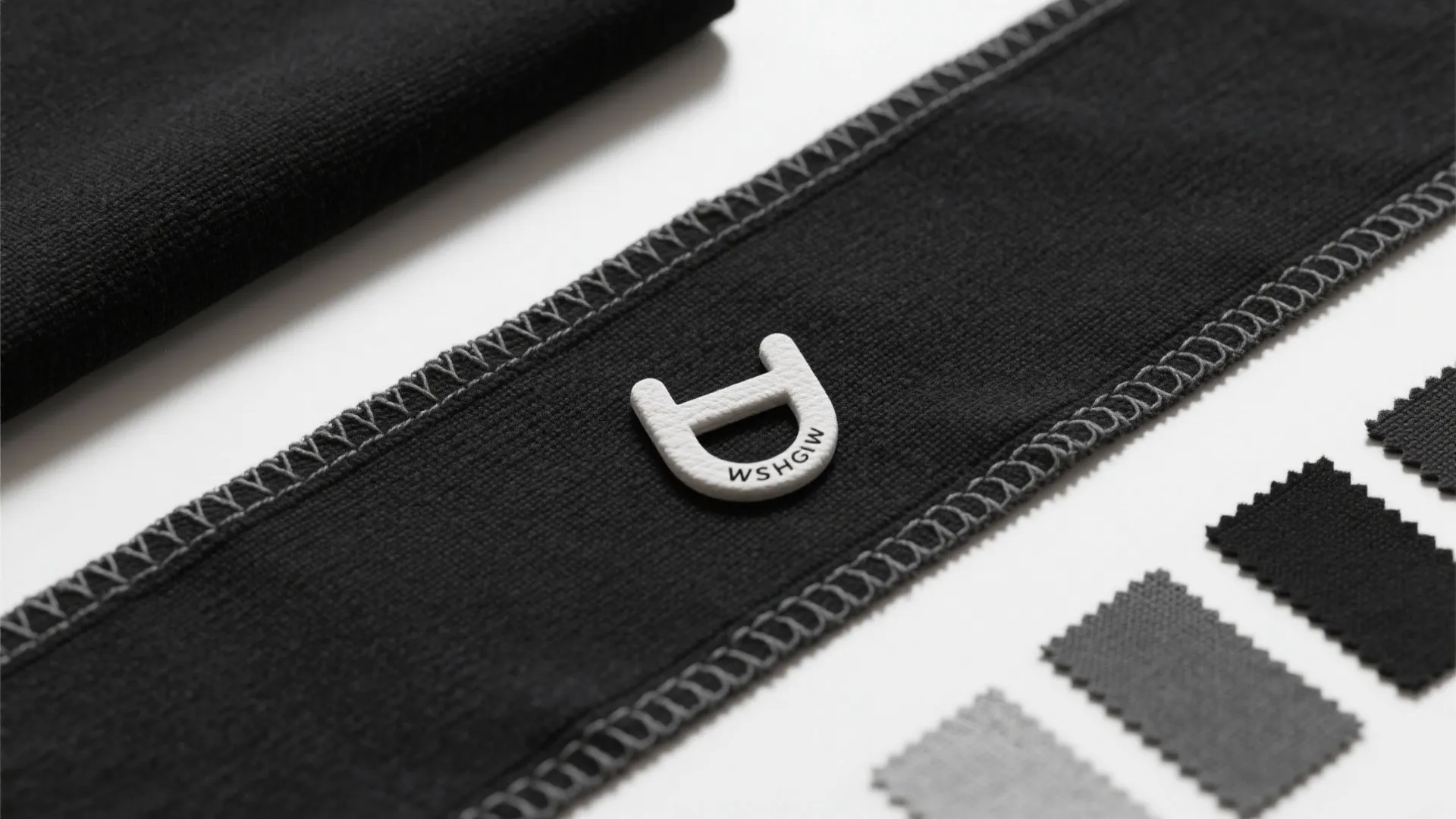 Flatlay of washable black cotton runner samples showing weave and stitched edges