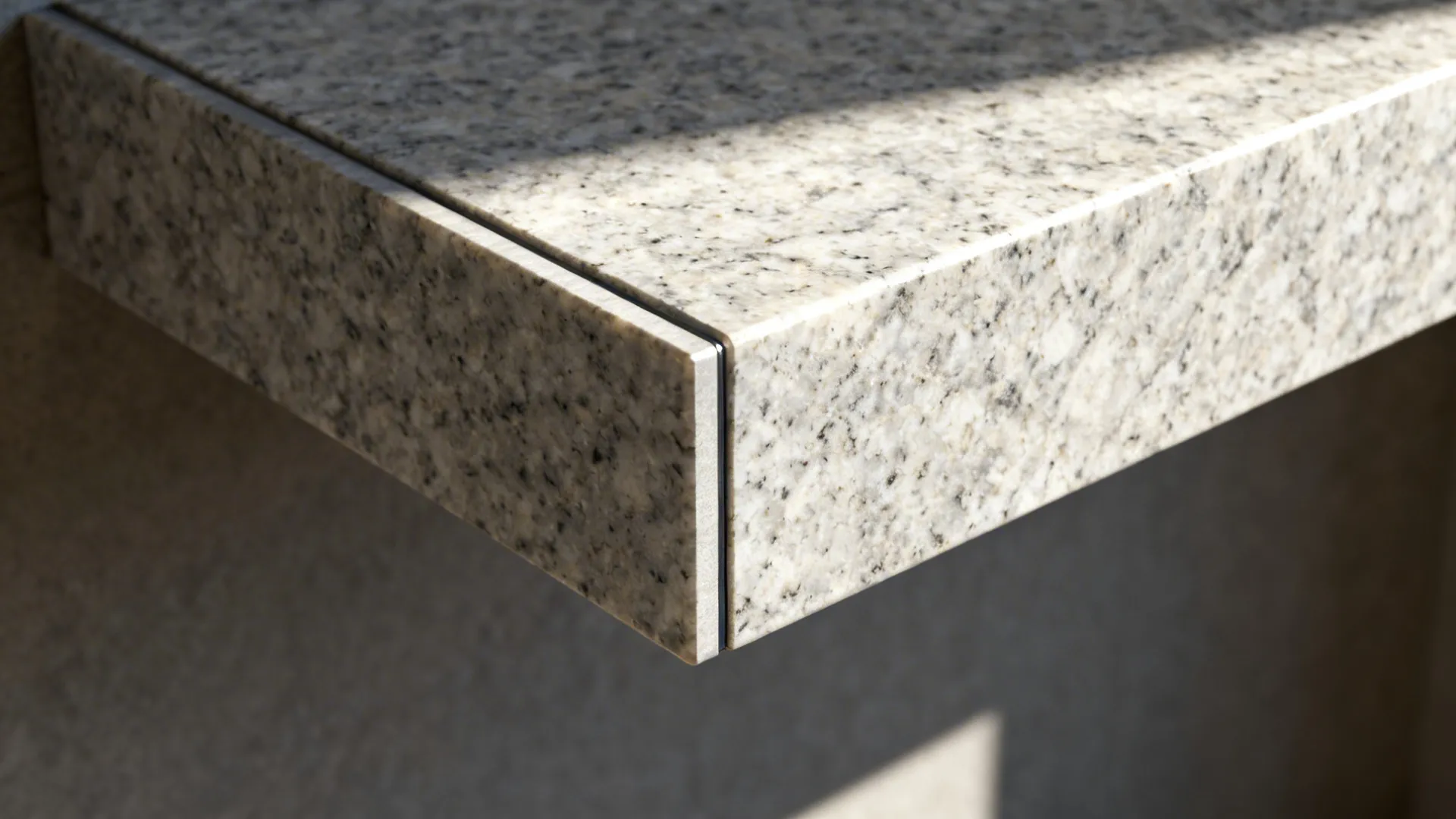 Macro of a granite corner shelf waterfall return showing a clean seam and honed texture.