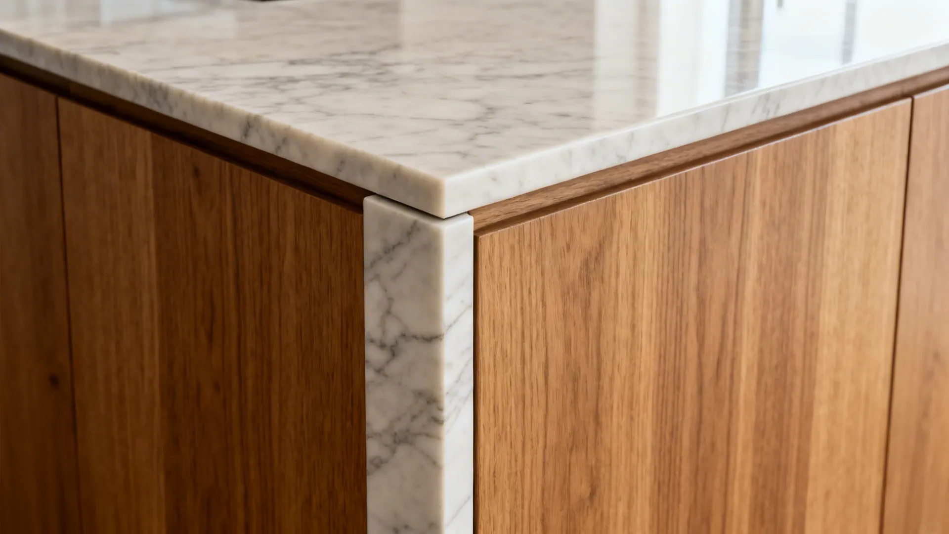 Close-up of a precise quartz waterfall mitre beside rift oak paneling on an L-shaped island.