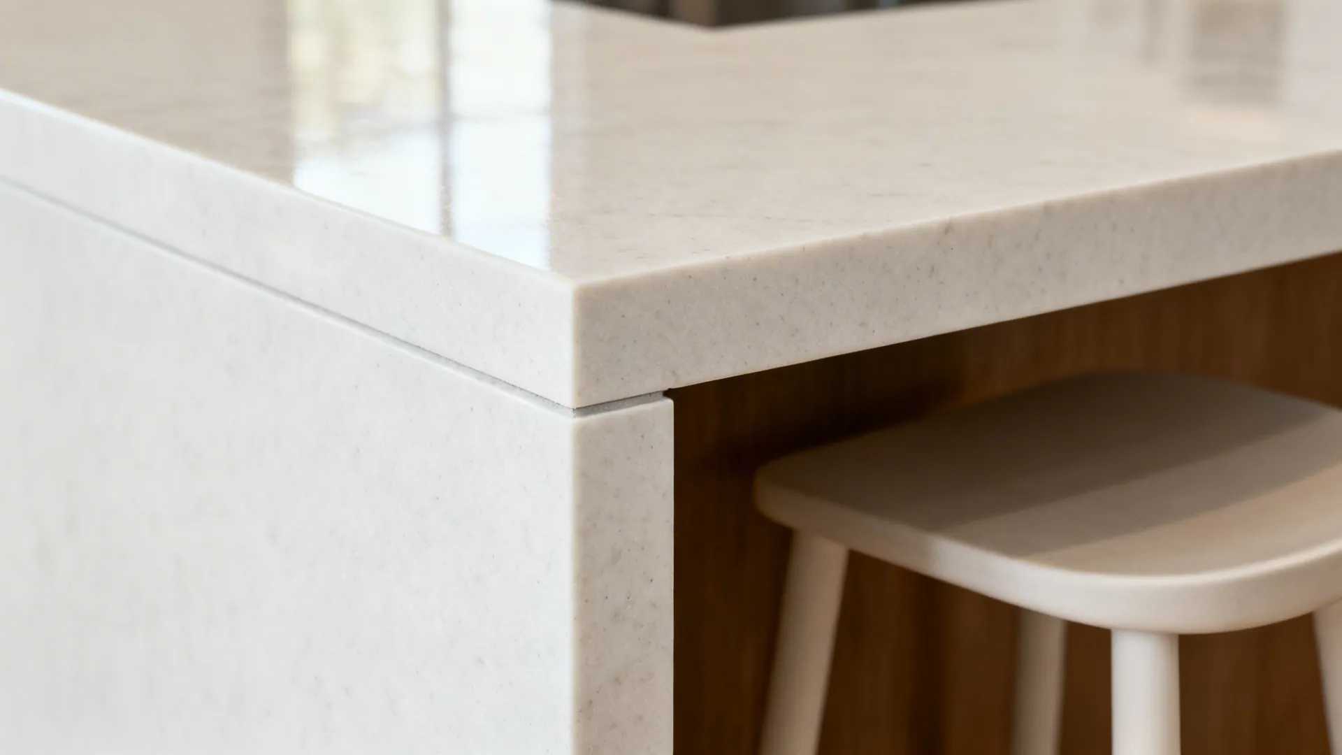 Close-up of a honed white quartz waterfall mitered corner with subtle grain.