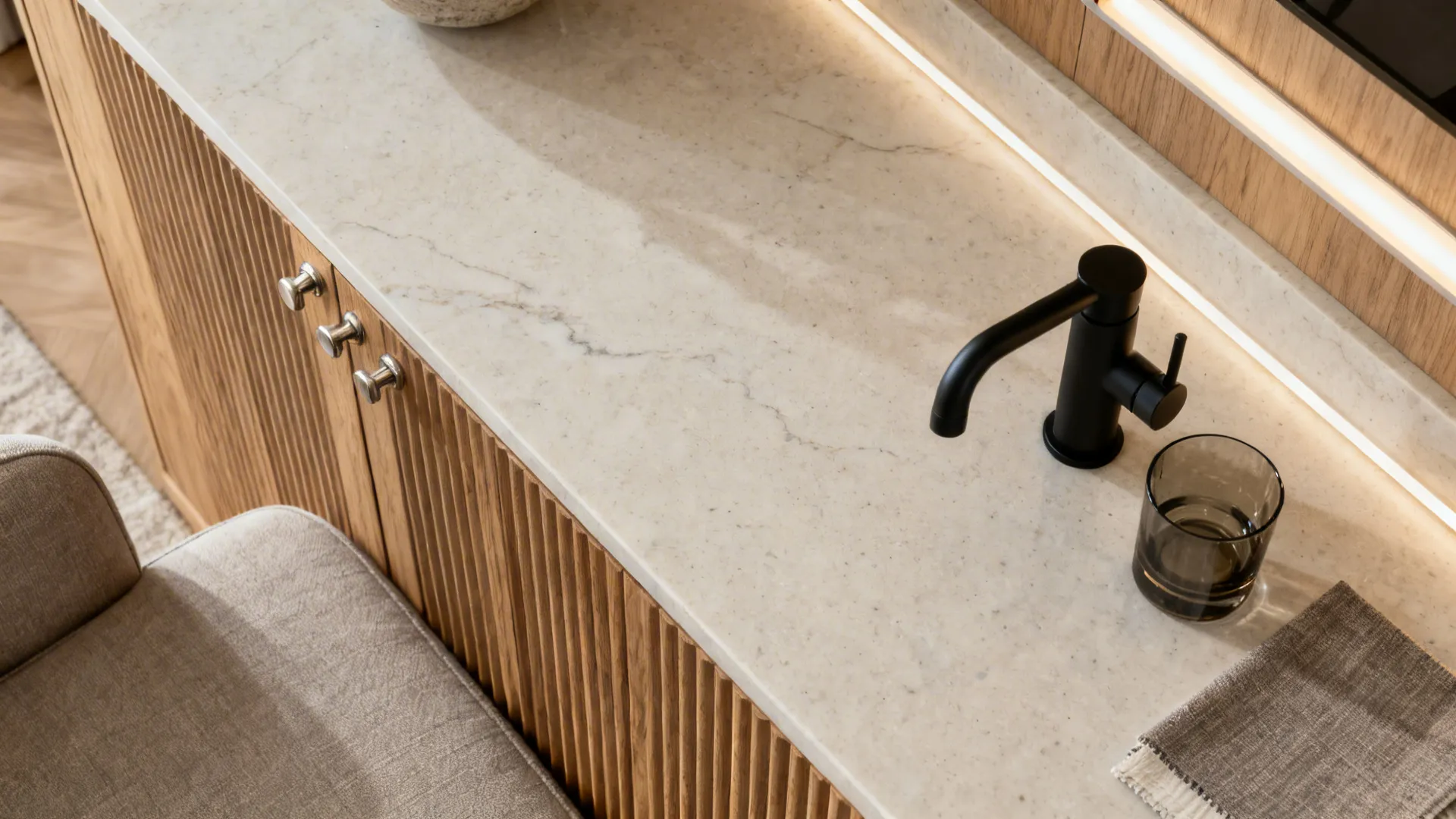 Top-down material board with fluted oak, light stone, metals, and lighting diffuser.