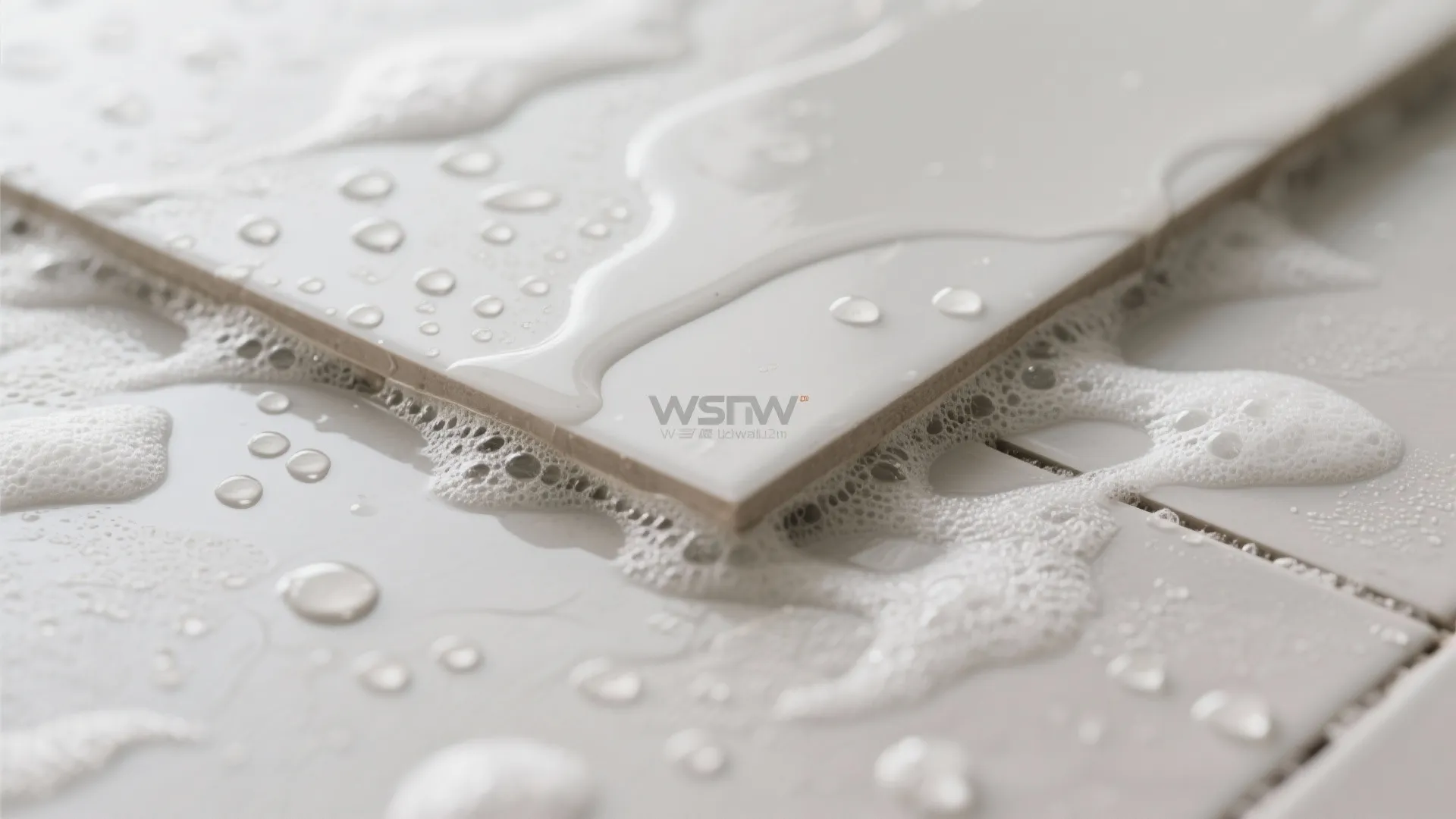 Close up of white floor tiles covered in water droplets and soap foam for safety