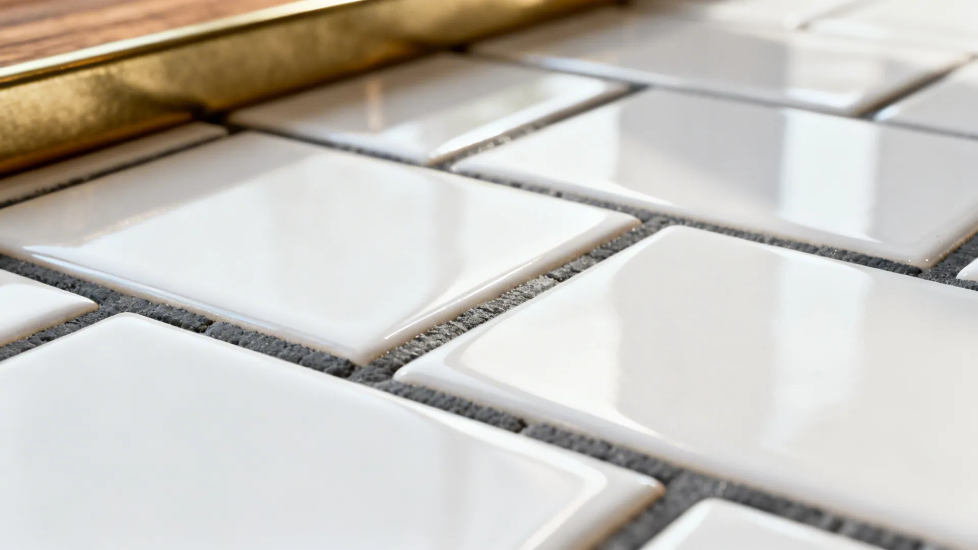 Close-up of white subway tiles with charcoal grout showing texture and reflections
