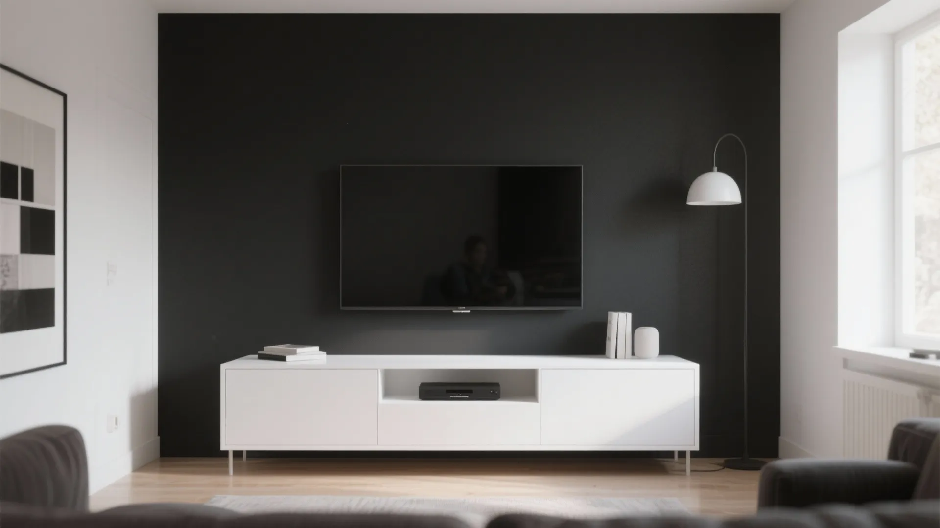 Minimalist living room featuring black wall, wall-mounted television, white low cabinet, and standing floor lamp