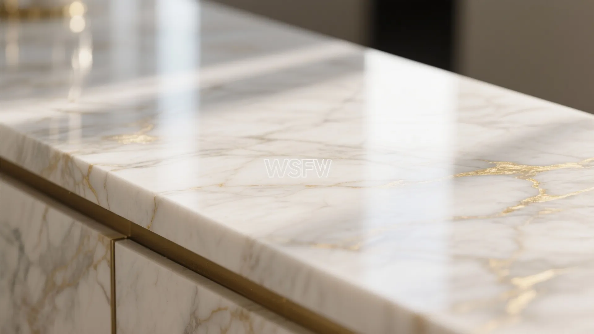 Close up of white marble countertop with gold veins and matching gold trim on cabinet