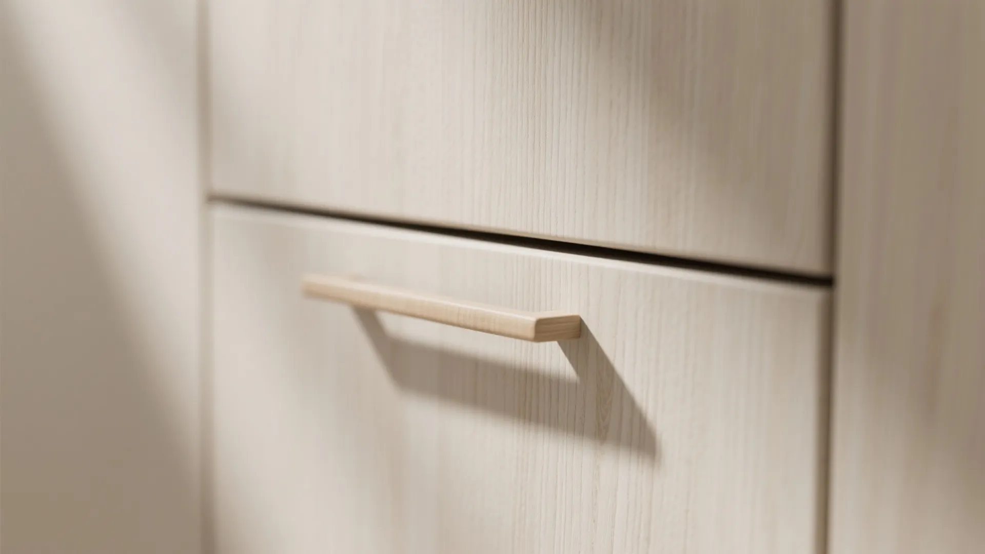 Macro view of matte white oak cabinet with integrated handle showing grain and finish