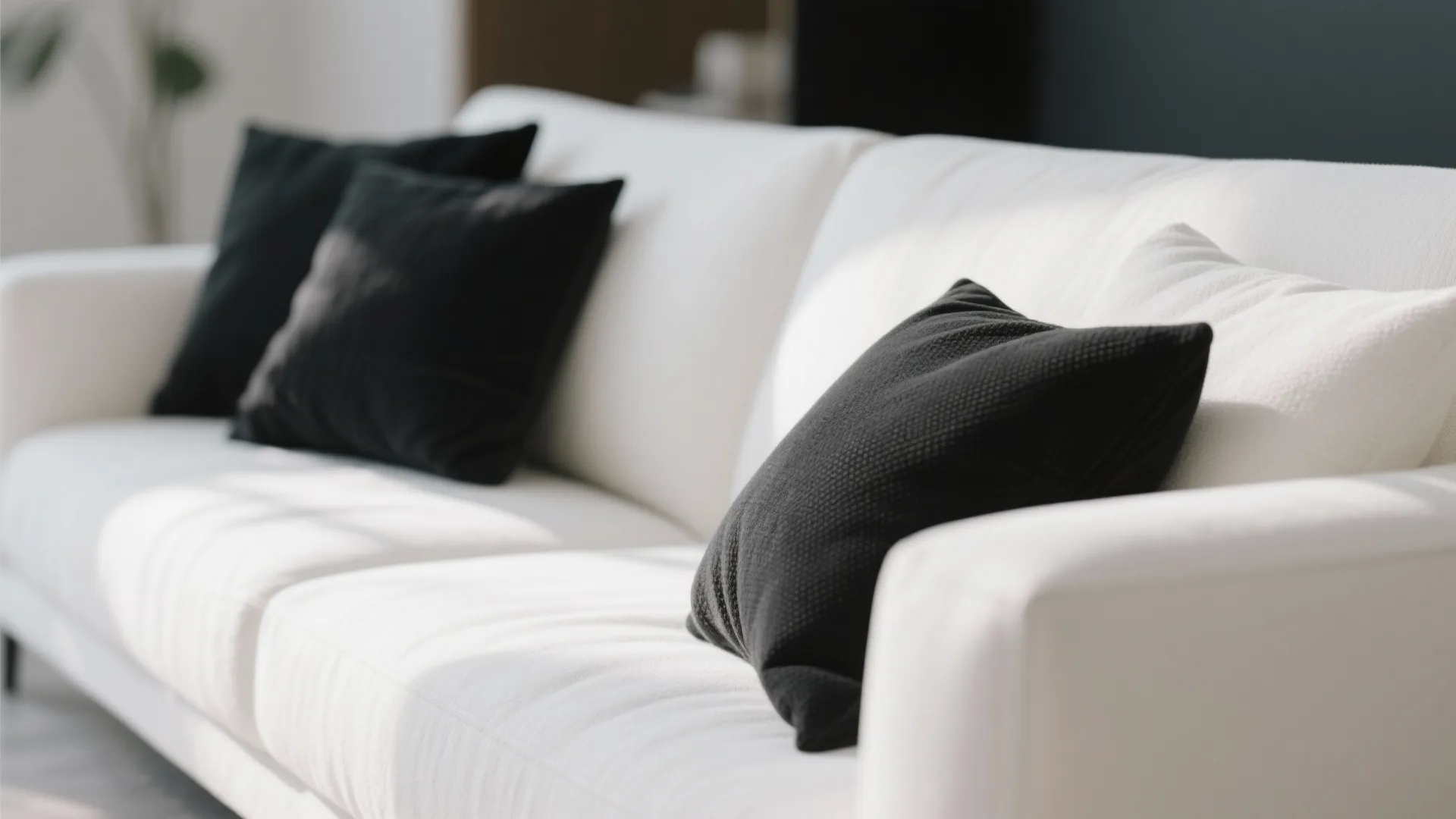 5. White Sofa with Black Throw Pillows