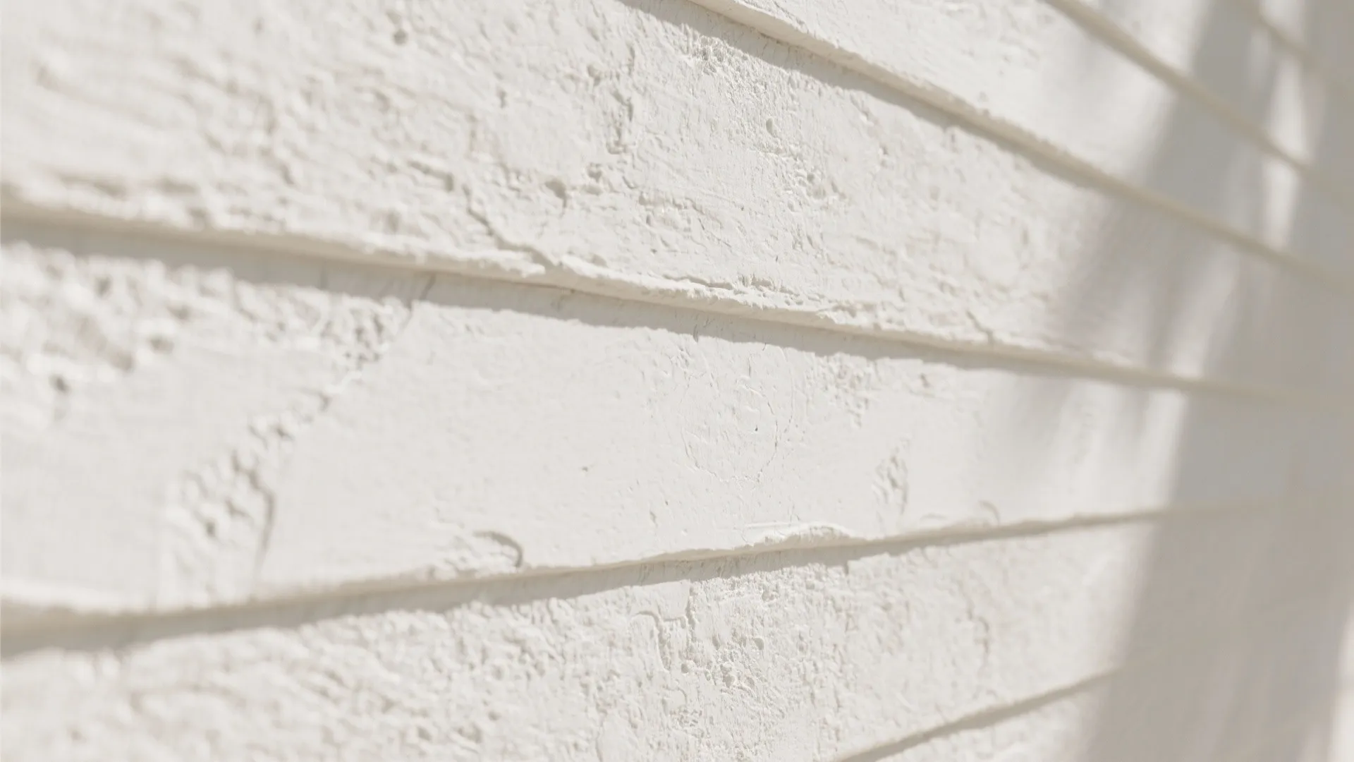 Macro close-ups of white textured surfaces: limewash, stucco, shiplap and smooth render showing shadow and depth.