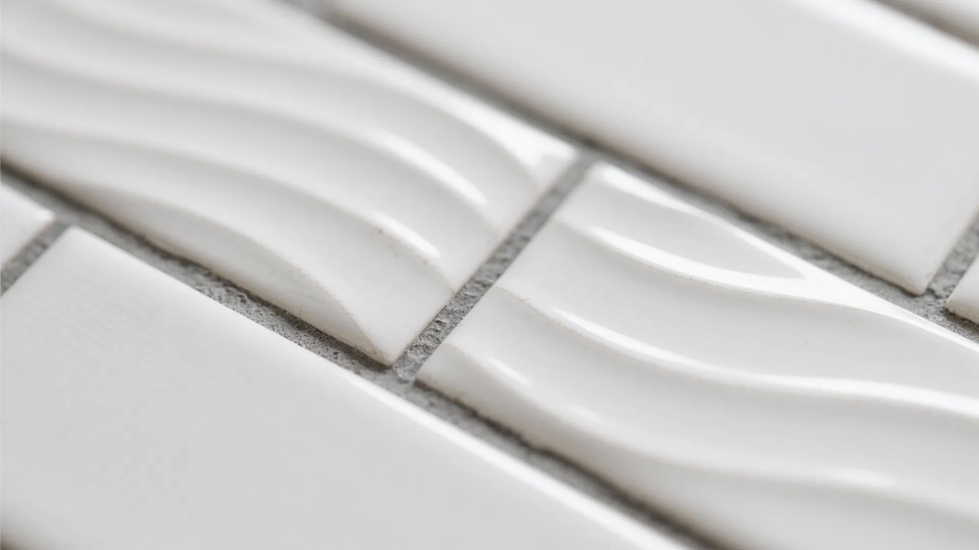 Close up view of white wall tiles with wavy texture and grey grout for bathroom