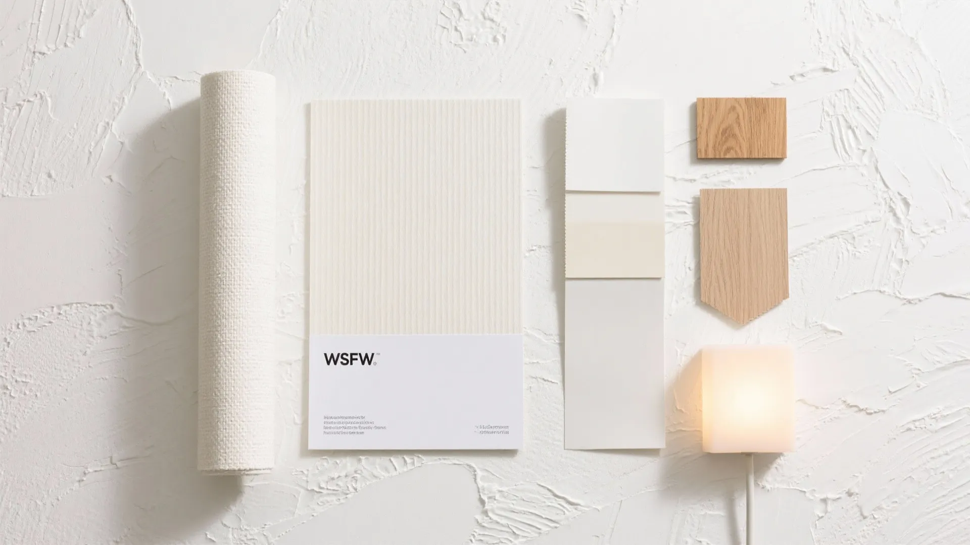 Interior design mood board with white wallpaper samples wood swatches fabric roll and light fixture