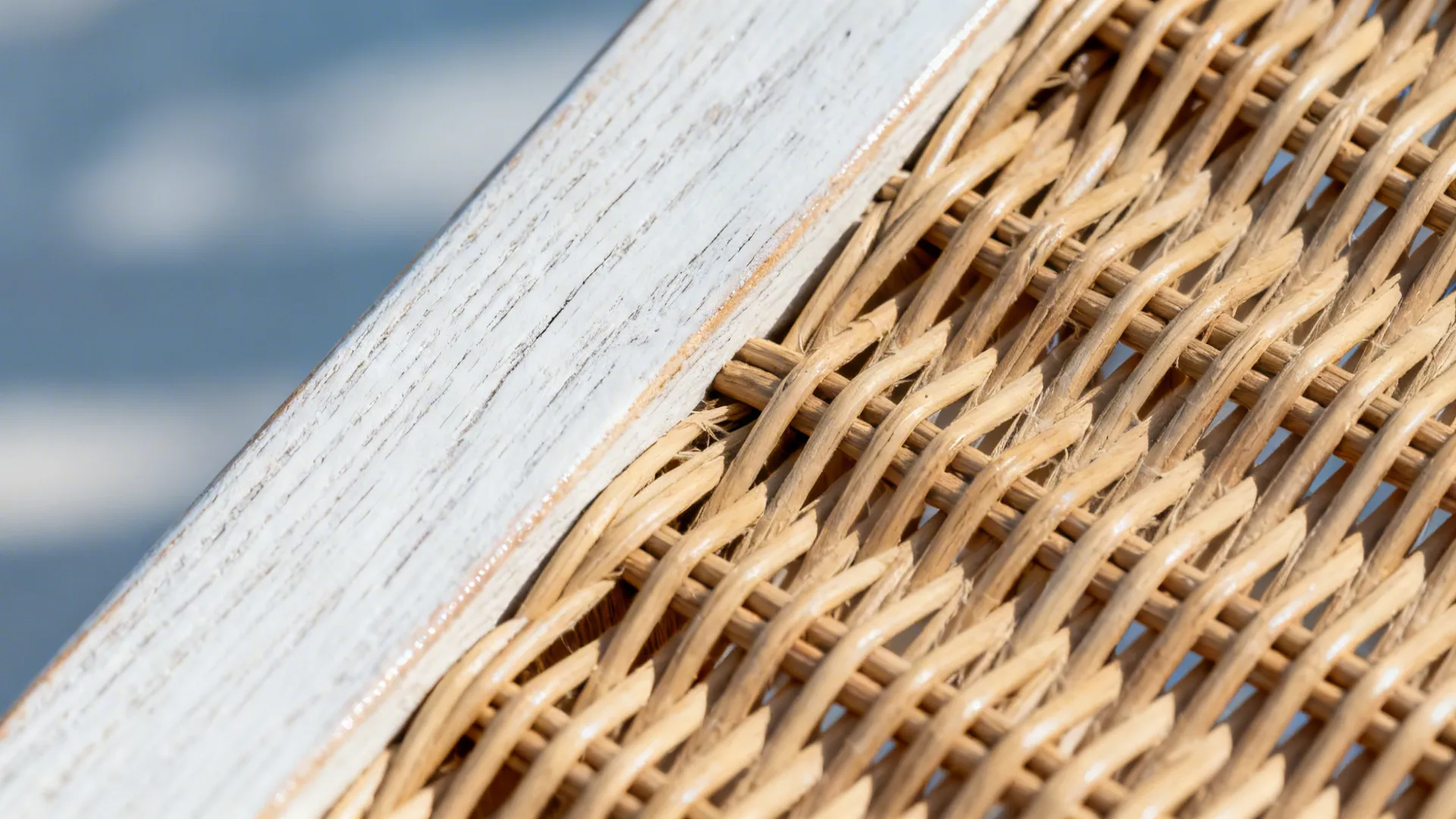Macro of whitewashed wood grain and woven rattan chair texture.