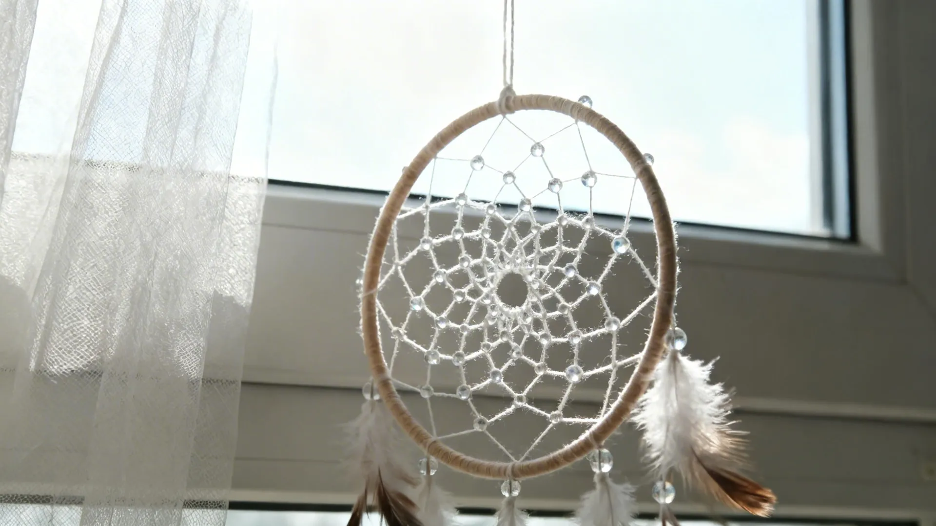 Translucent dream catcher near a sunlit window, beads shimmering softly in afternoon light.