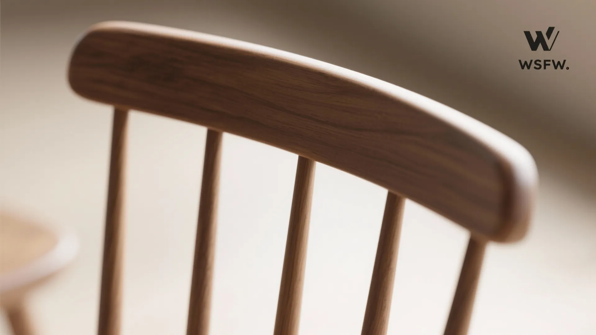 Close-up of modern Windsor chair spindles and curved crest rail with a matte finish.