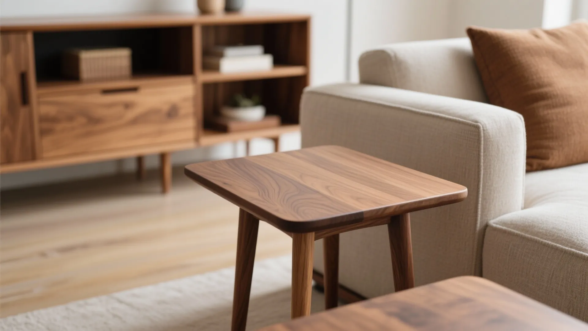Close-up of a small wooden table next to a cream sofa in a bright room