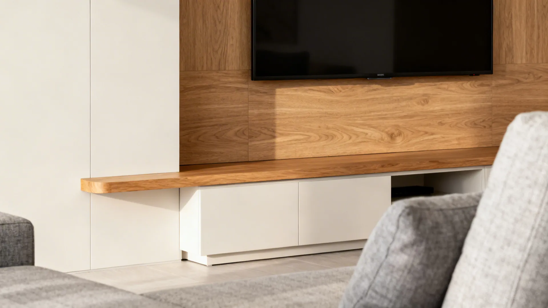 Living area with a wood-look laminate TV panel and a solid timber ledge in a light neutral scheme.