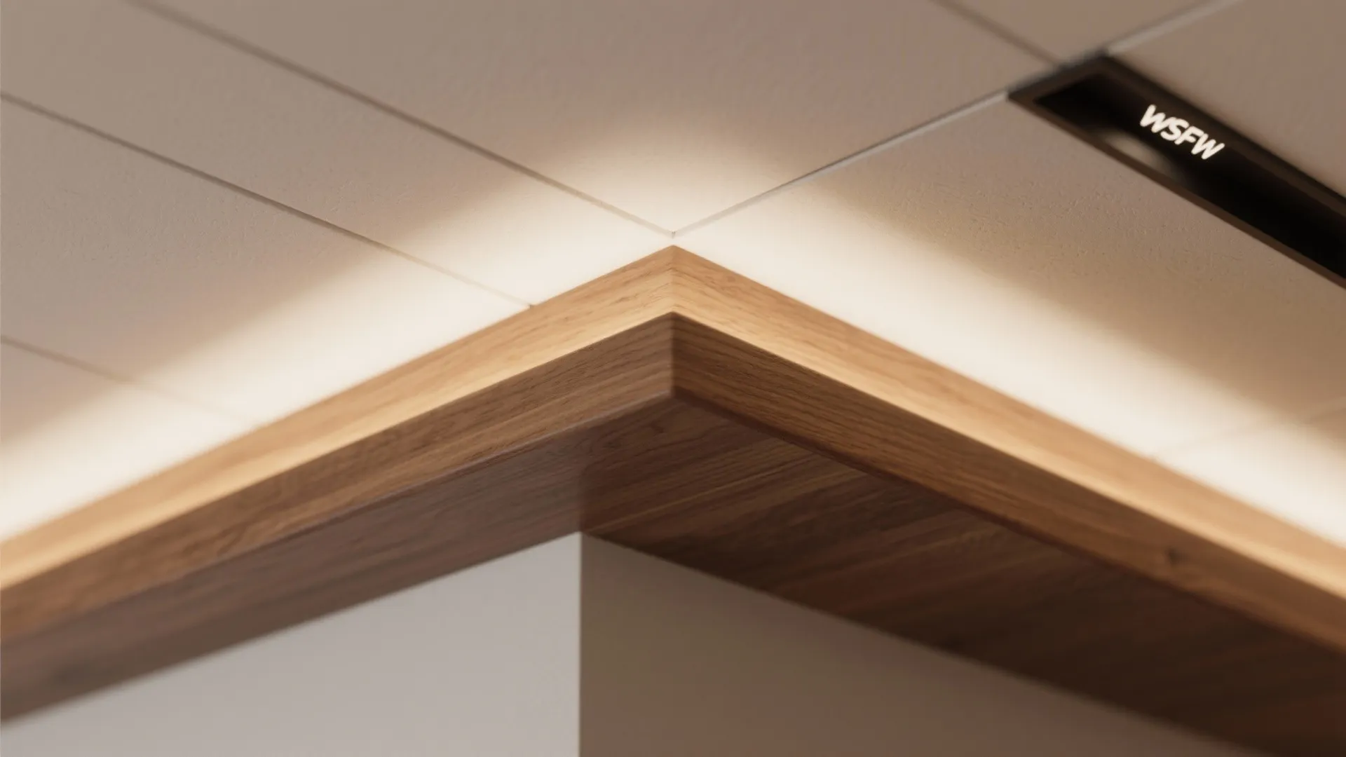 Close up of wooden wall panel corner with soft hidden light fixture and white ceiling tiles