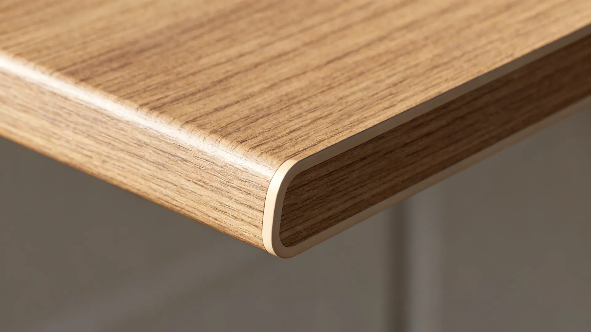 Close up of a wooden table edge with a light colored smooth and protective plastic strip