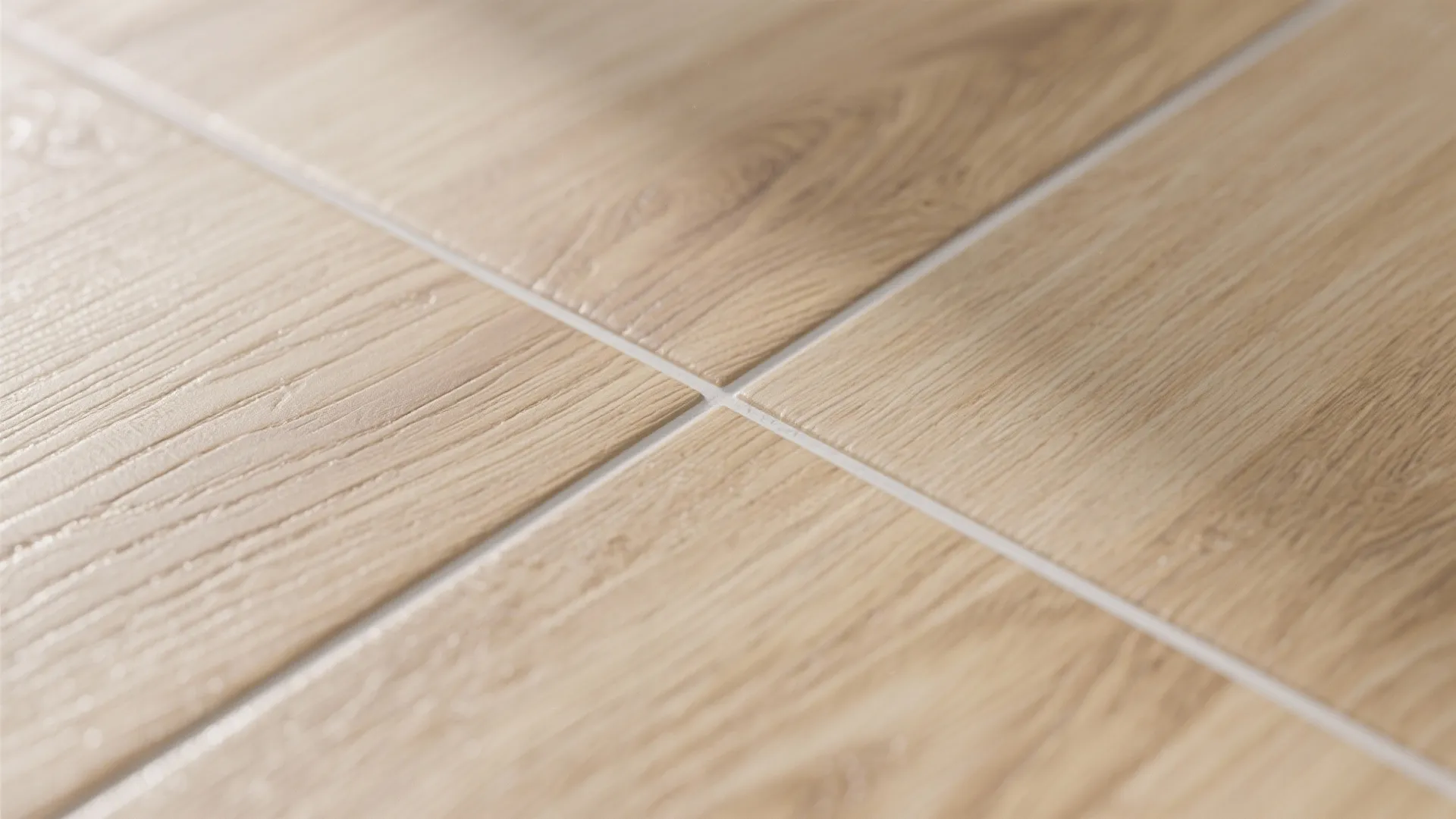 Close up view of light brown wood grain floor tiles with clean white grout lines