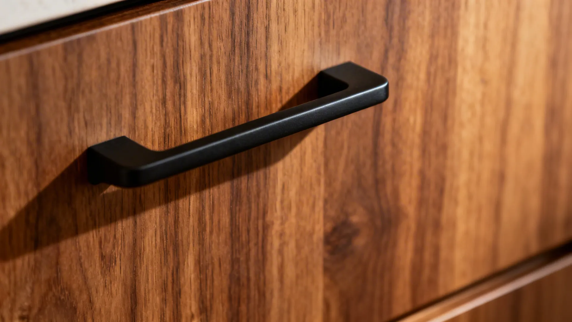 Macro of wood grain meeting a matte black handle with crisp edge lighting.