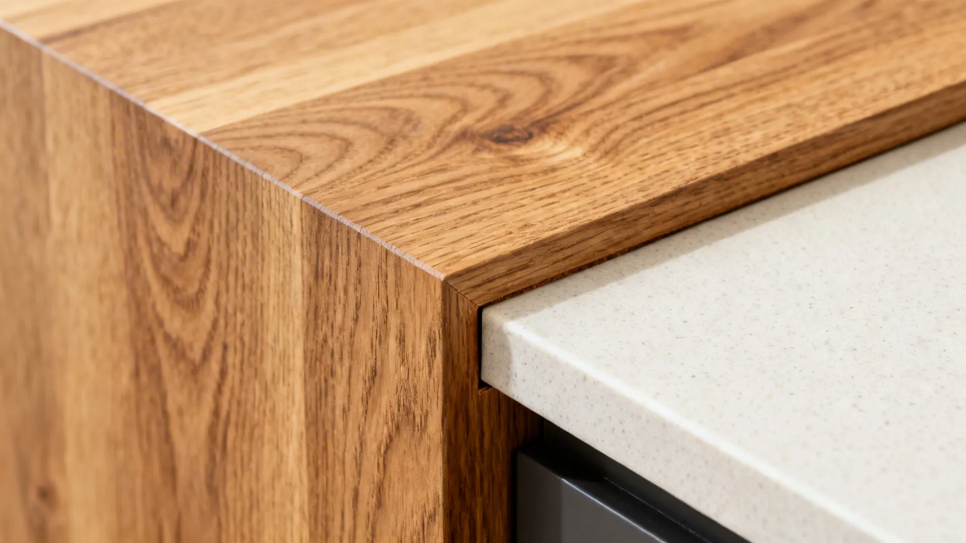 Close up of natural wood countertop corner meeting a white stone surface in a kitchen