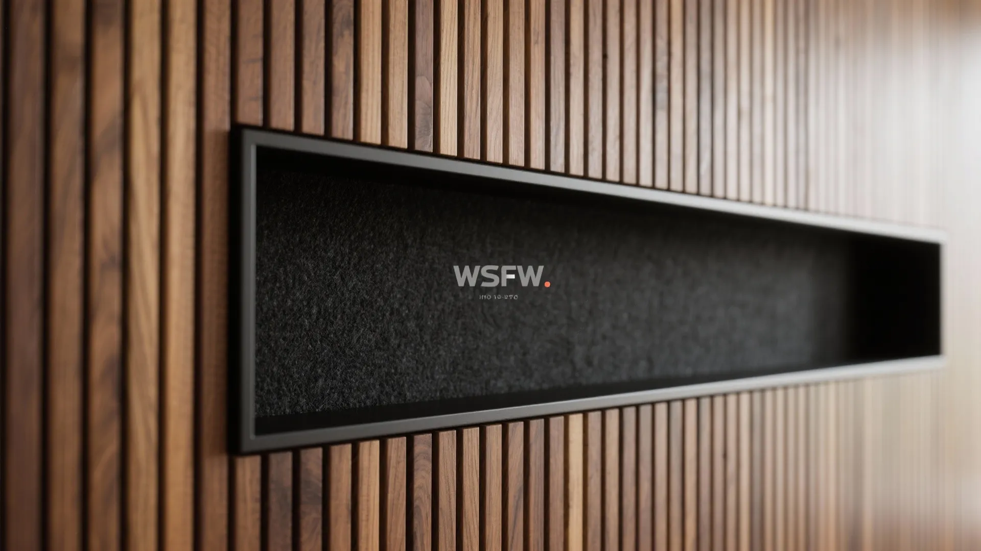 Macro of oak slat feature wall with black acoustic felt framing a TV area.