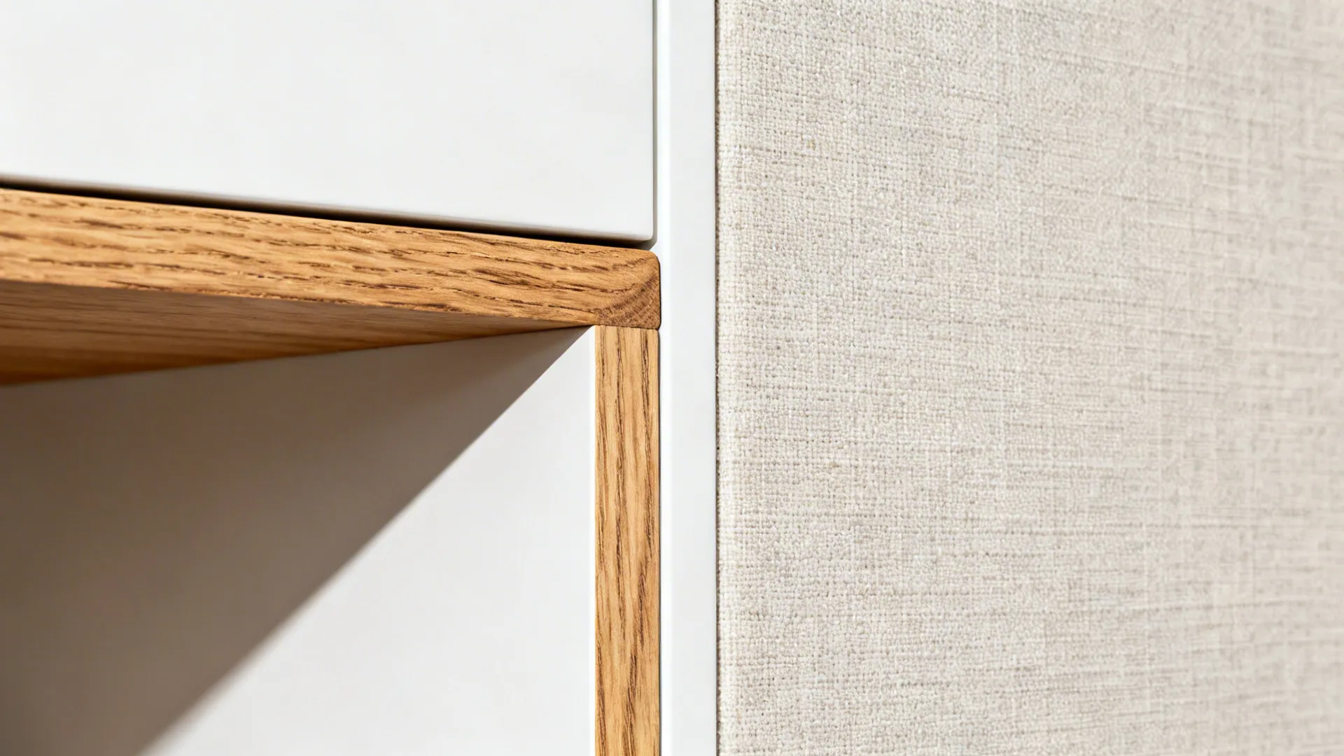 Macro detail of rift-cut oak meeting matte white panel with linen texture nearby.