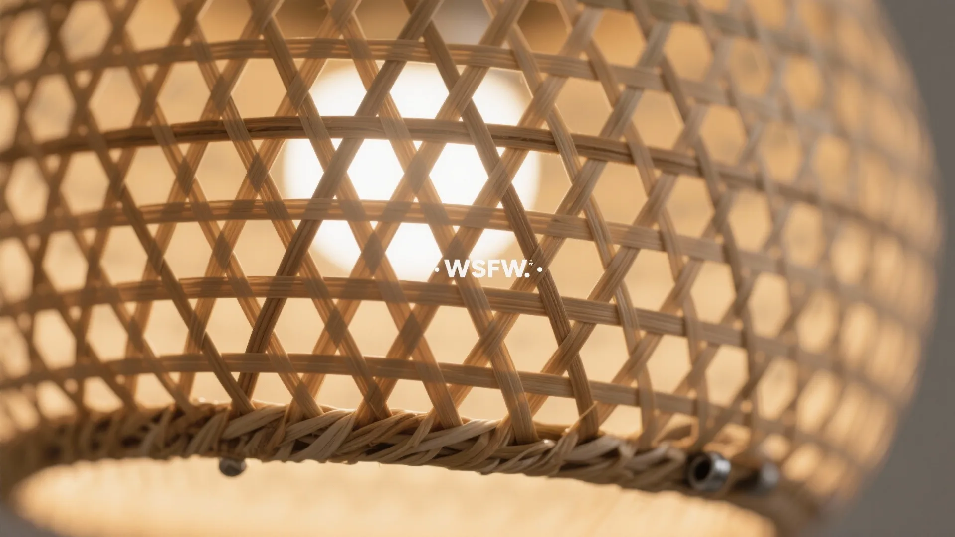 Close up of a woven wooden ceiling light shade with a warm glowing light bulb