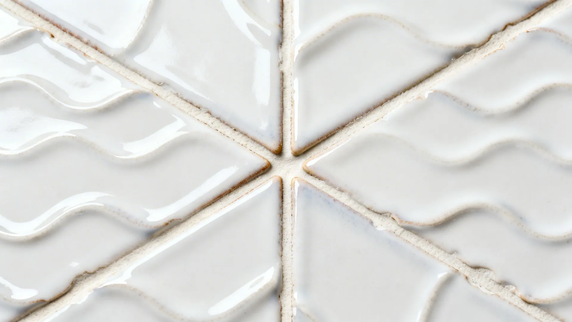 Macro of glossy zellige showing wavy surface, tonal variation, and off-white grout.