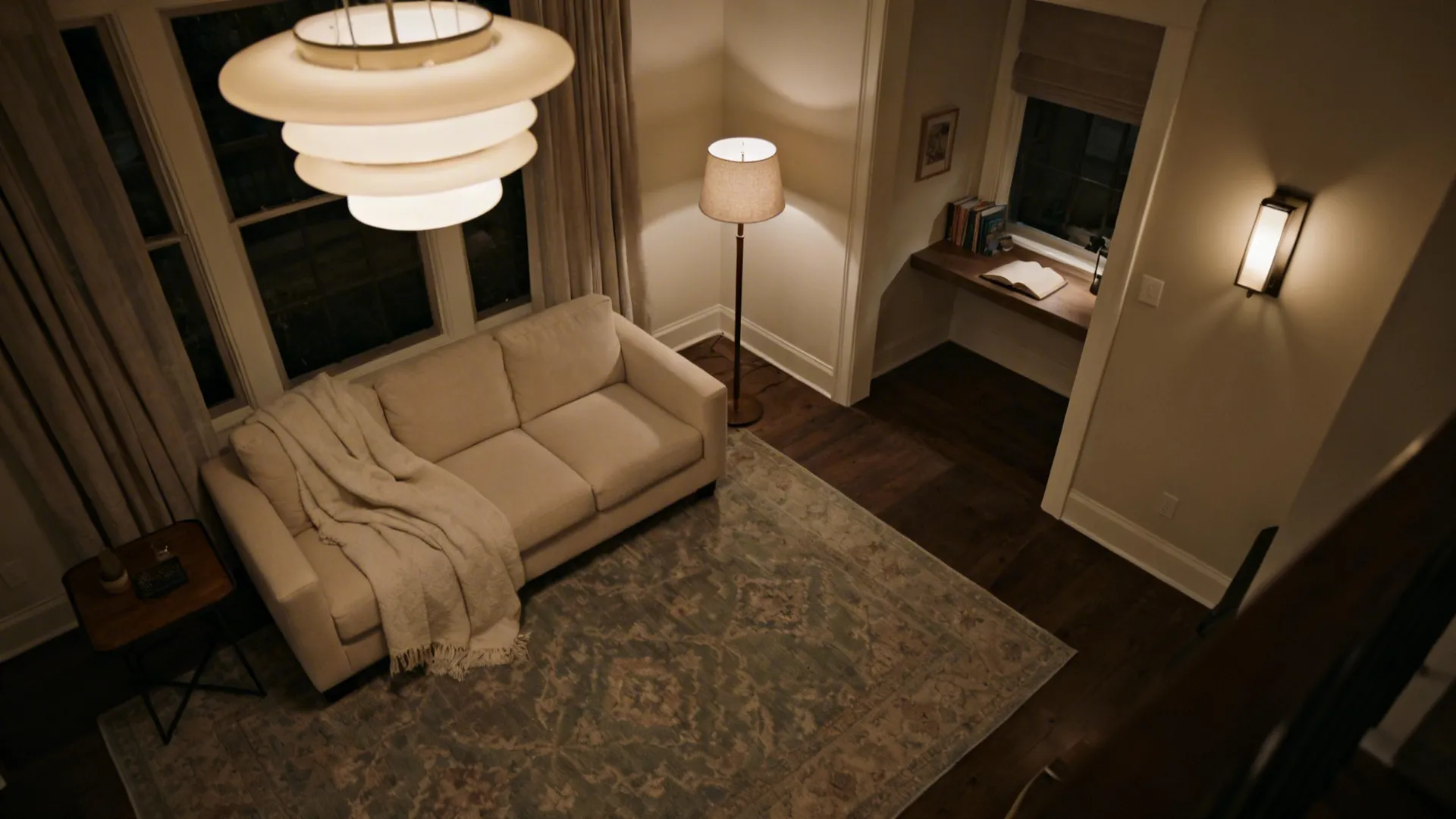 Living room with a patterned rug defining seating area and layered lighting creating distinct zones.