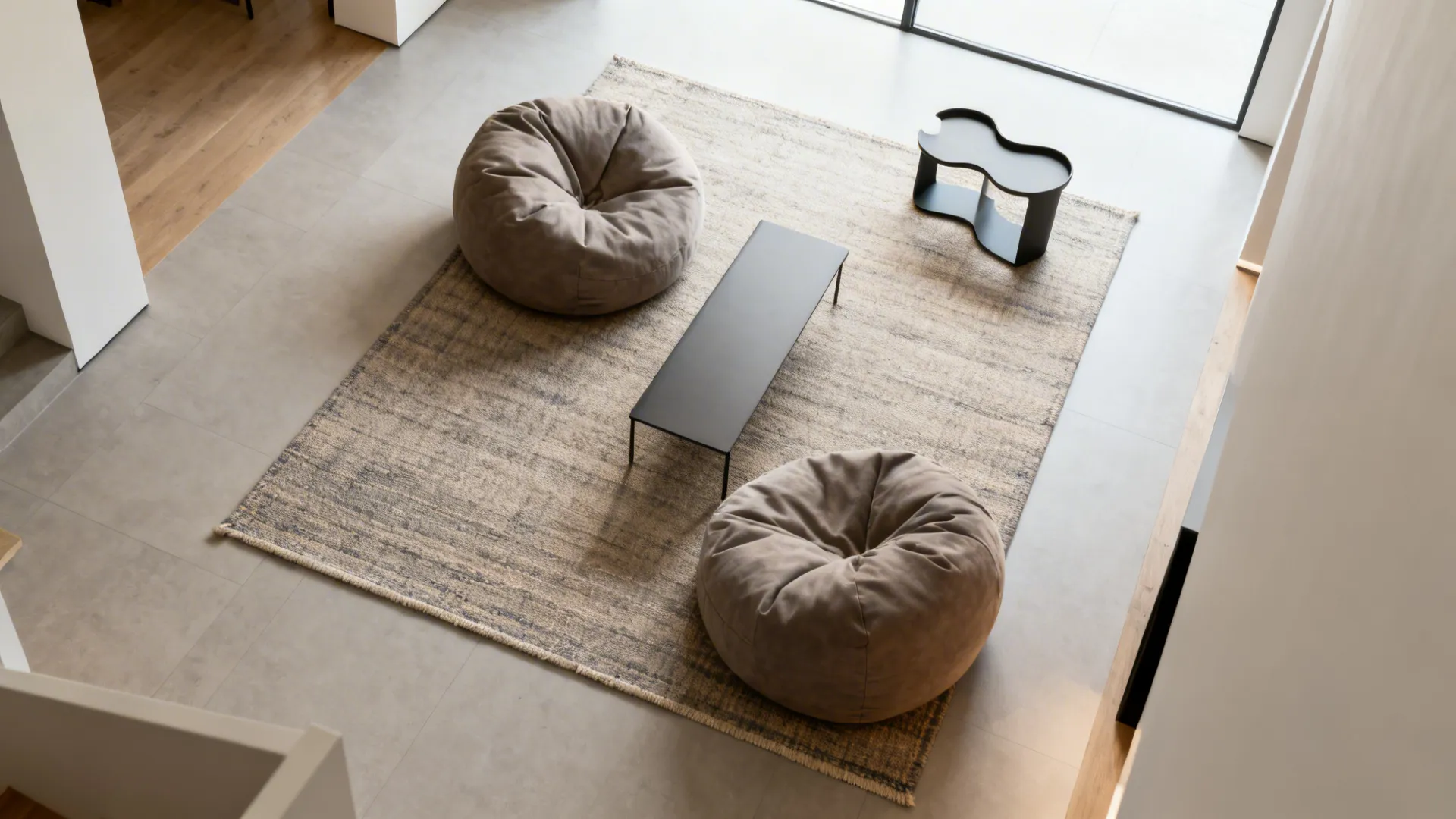 Top-down view of a flatweave rug zoning two bean bags with a slim table and clear pathways.