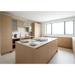Modern kitchen featuring wood cabinets white countertops kitchen island with blueprints calculator and material samples